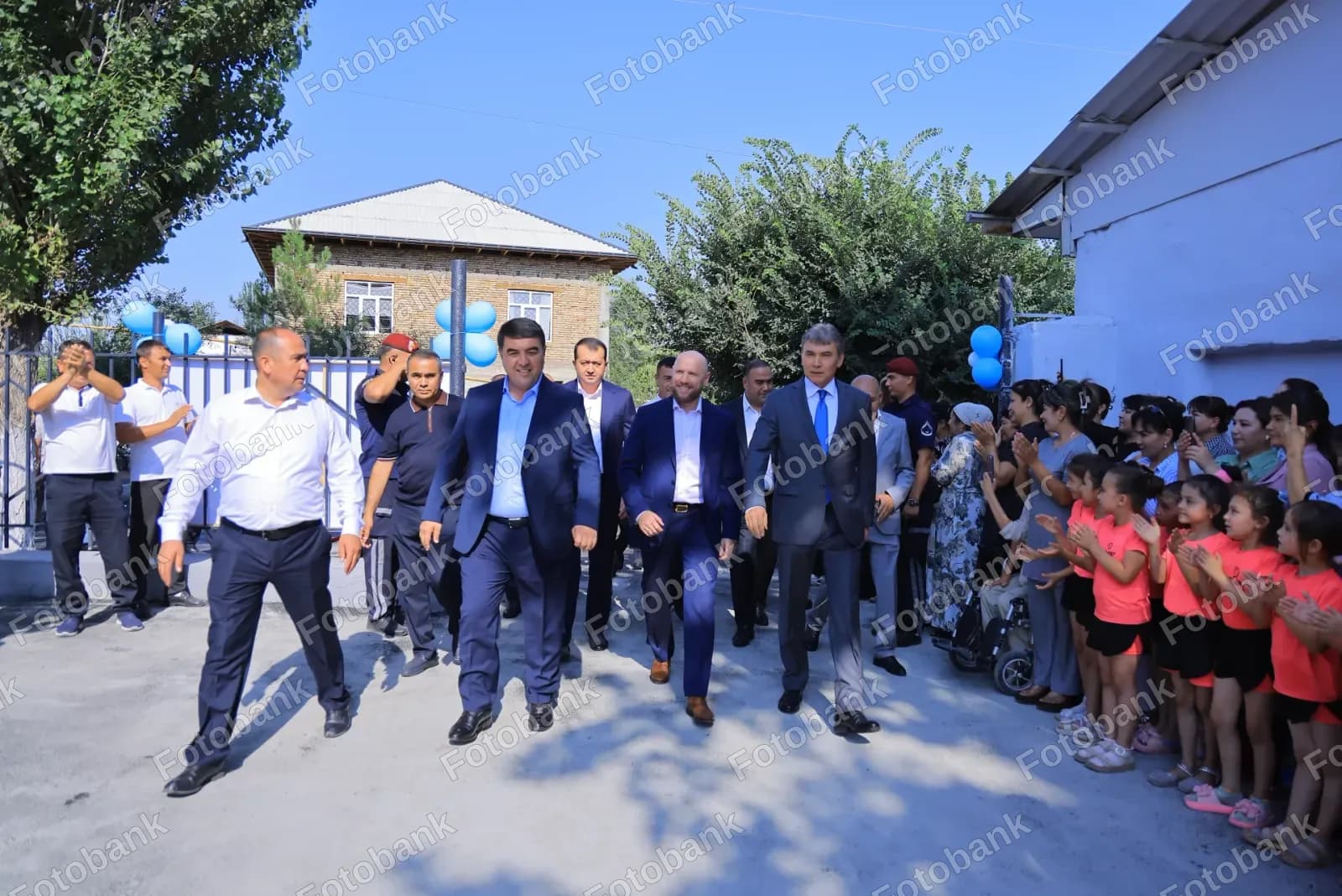 Amaldorlar olqishlayotgan bolalar yonidan oʻtib ketmoqda Qo'l jangi