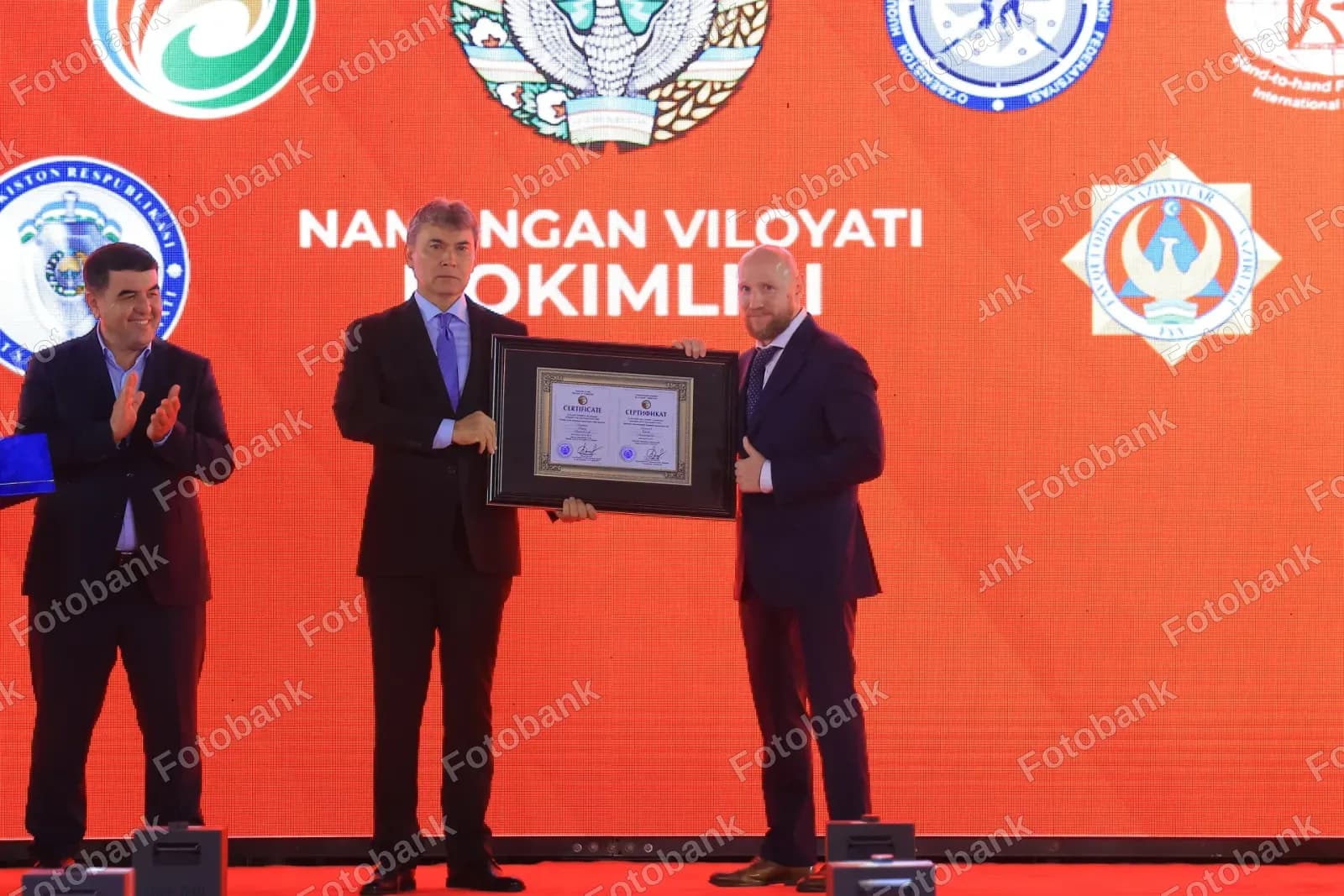Rasmiylar ramkali mukofot sertifikatini topshirmoqda