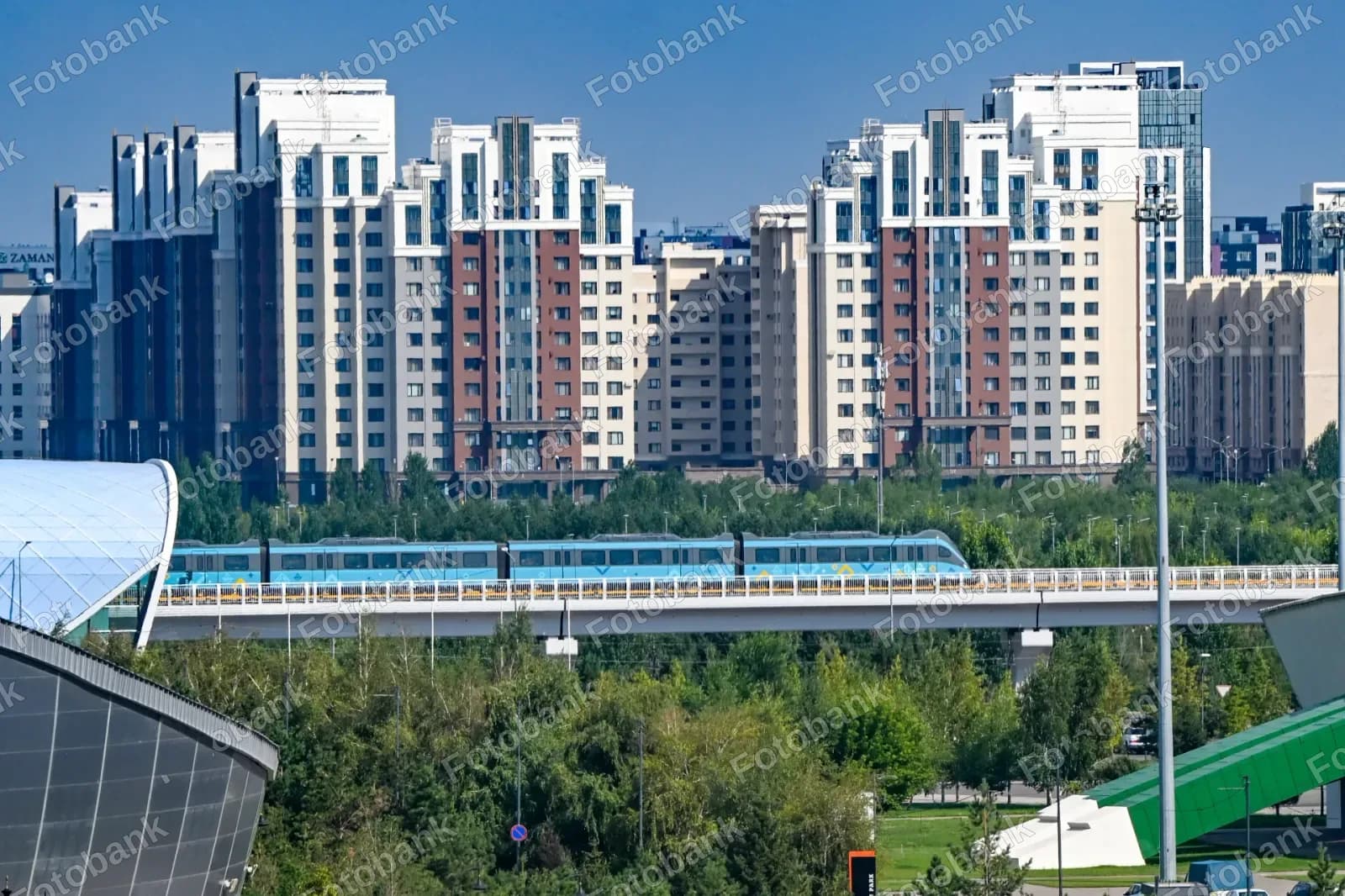 Синий поезд пересекает городской мост