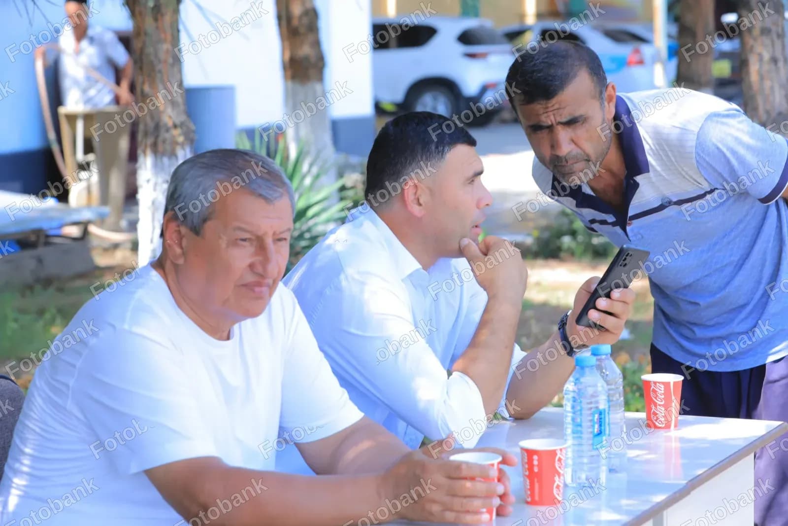 Three men discussing mobile phone