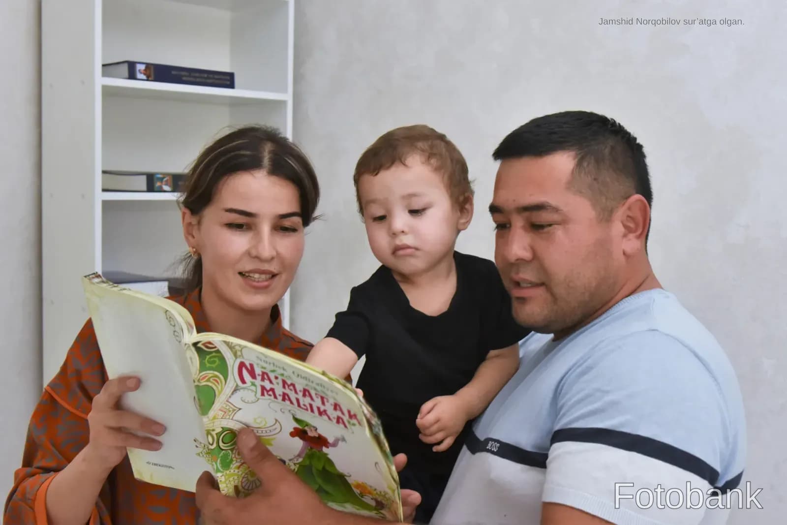 Oila xonada birga kitob oʻqimoqda