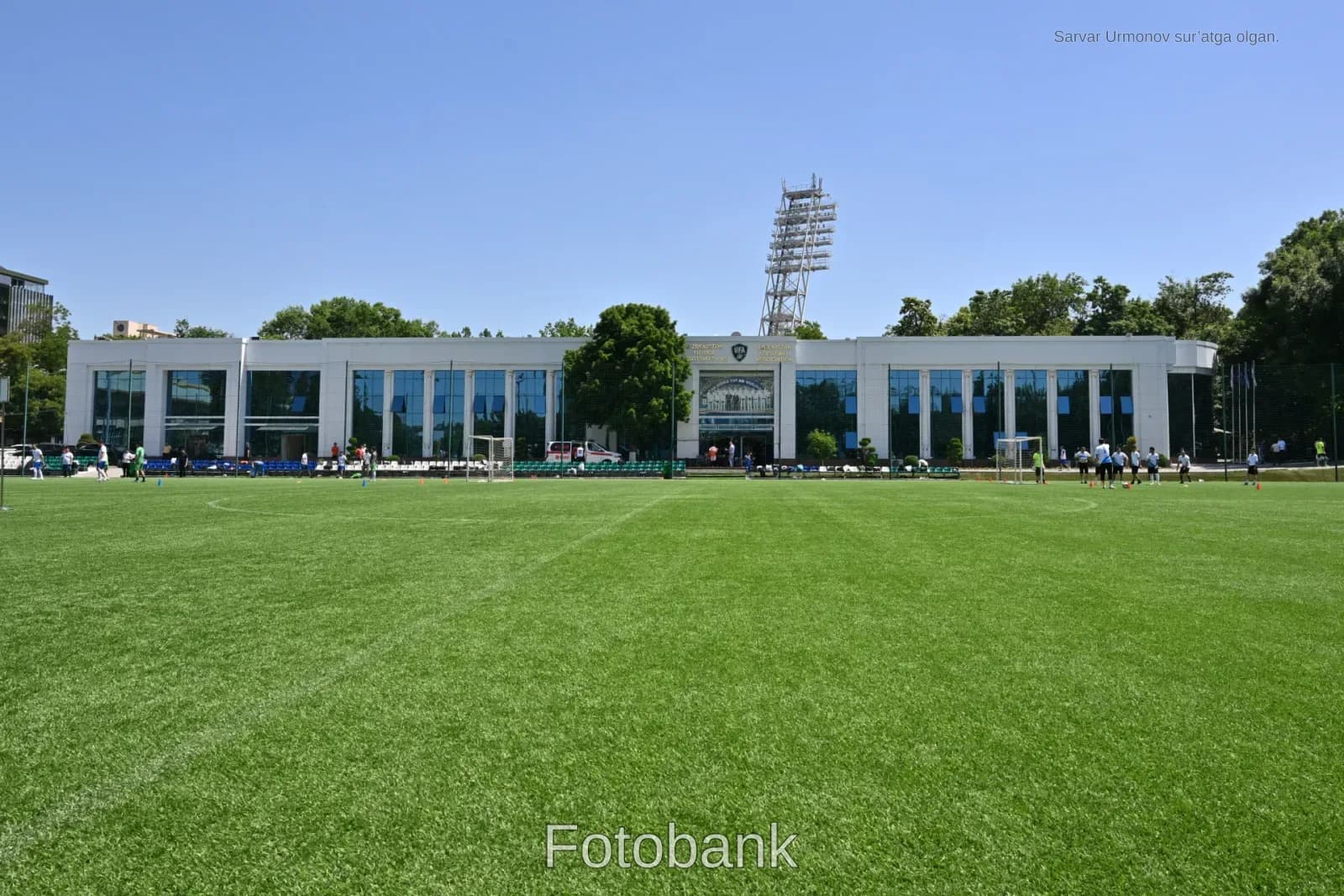 Yashil futbol maydonida mashq qilayotgan sportchilar