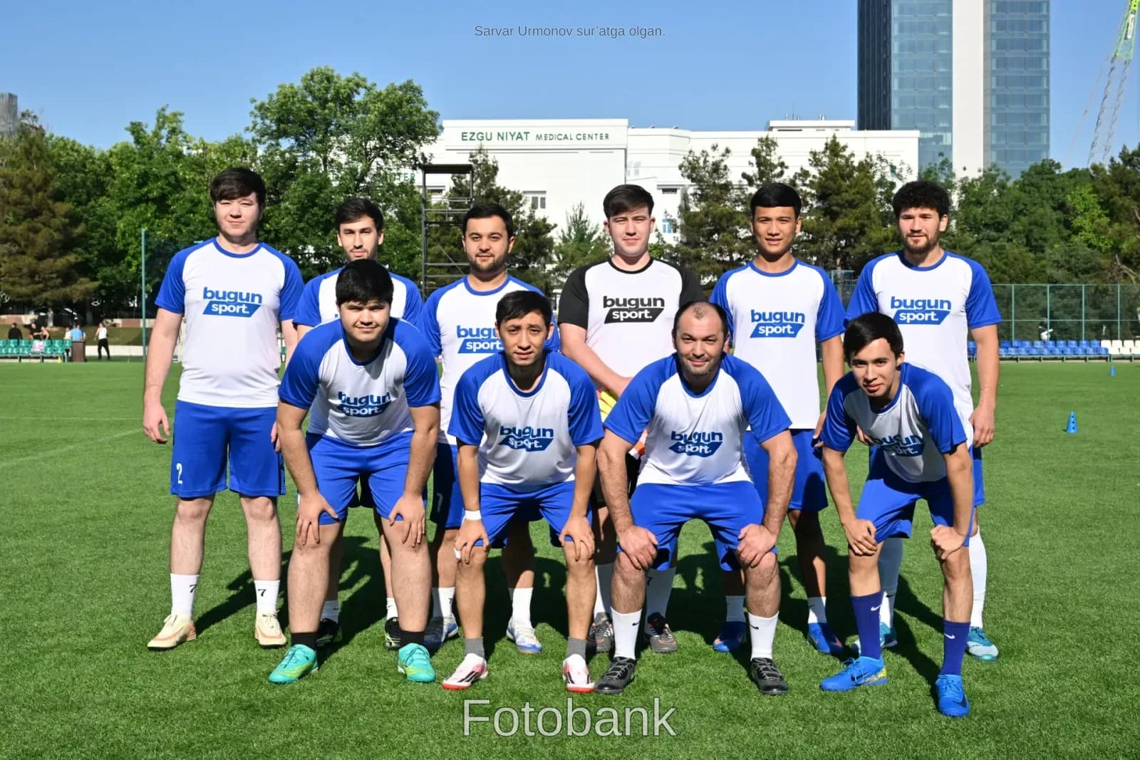 Футбольная команда позирует на поле
