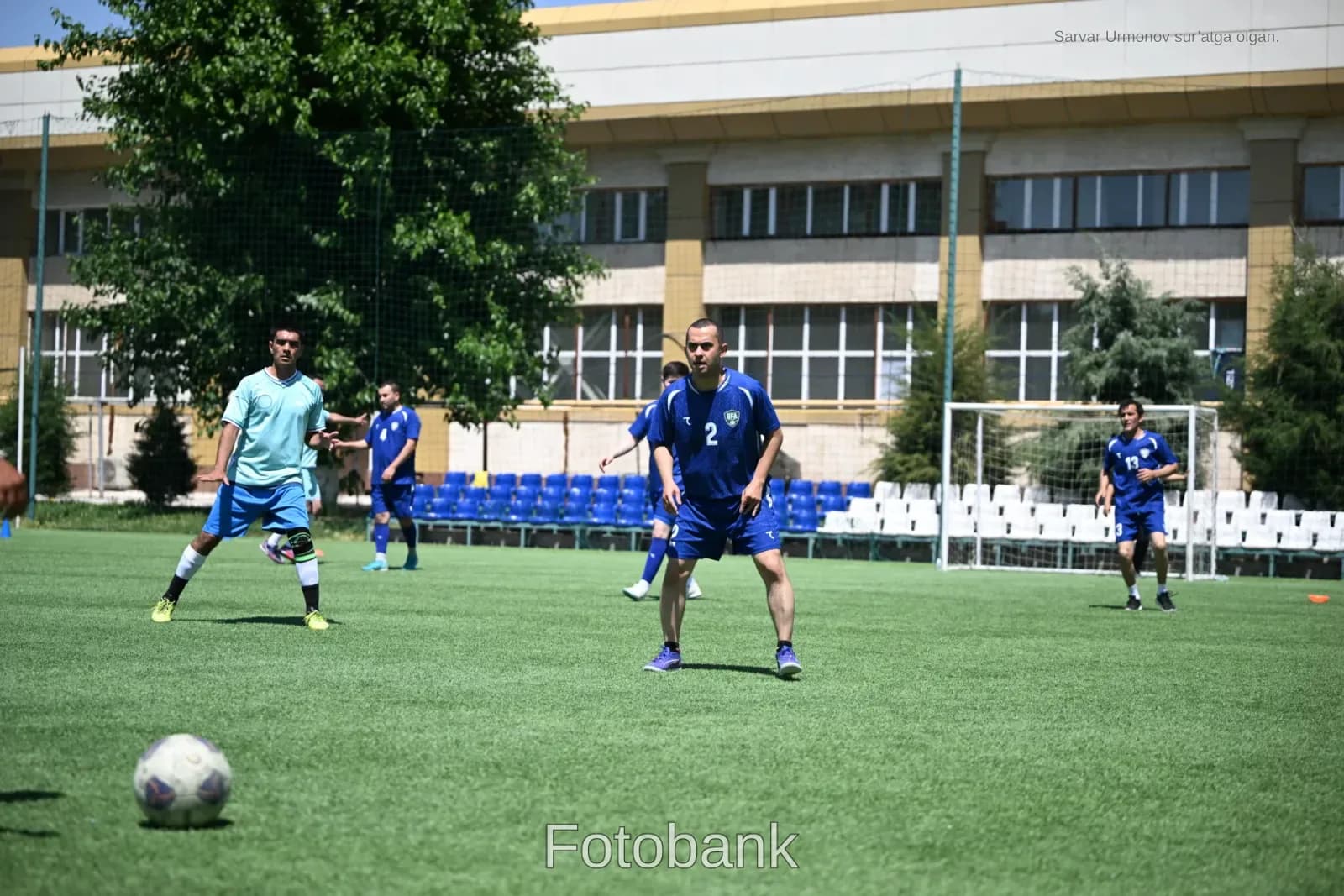 Erkaklar ochiq maydonda futbol oʻynashmoqda
