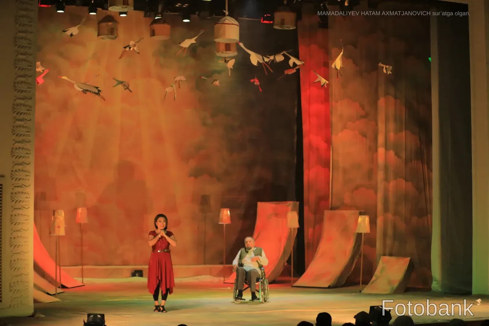 Teatr sahnasidagi ijrochilar dekoratsiya bilan