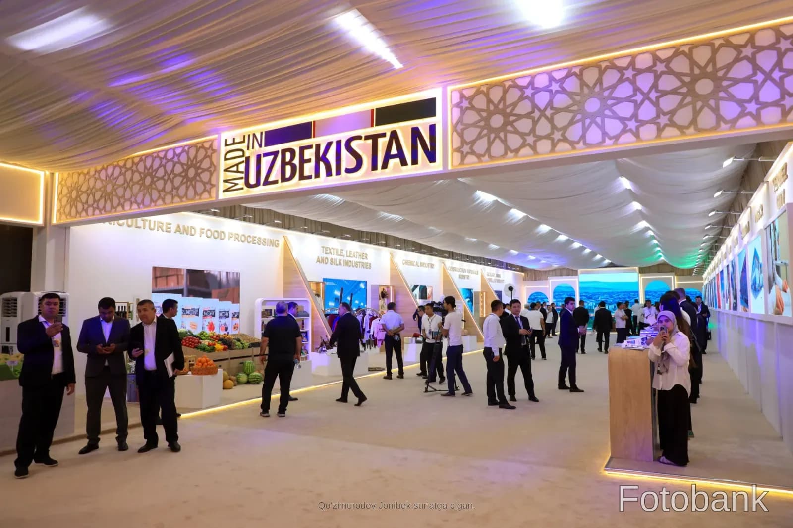 "Made in Uzbekistan" yozuvi tushirilgan katta koʻrgazma zaliga toʻplangan odamlar