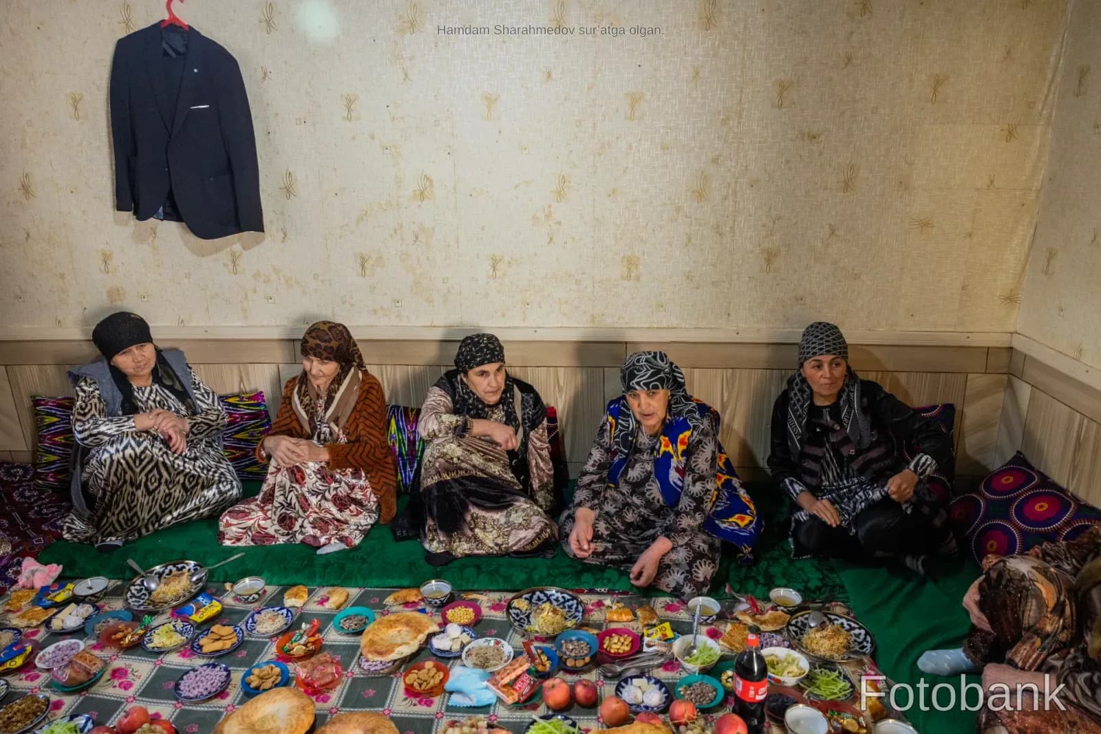 Group of women gathered around a traditional spread of food indoors