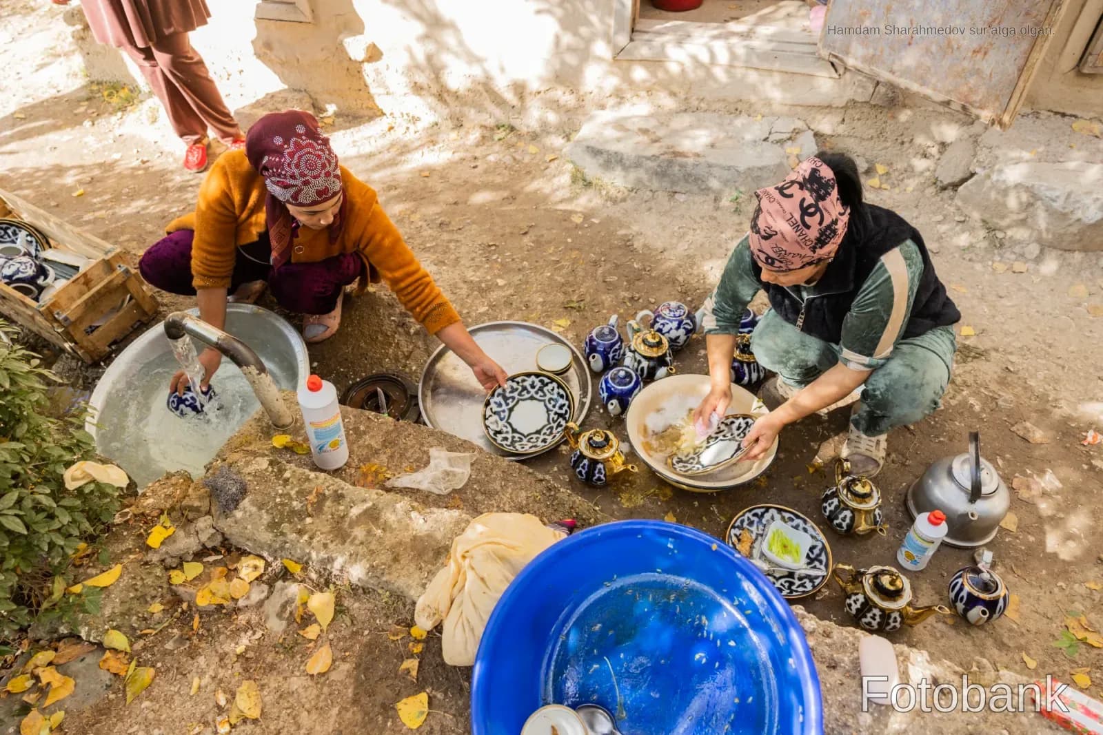 People washing ceramic plates outdoors