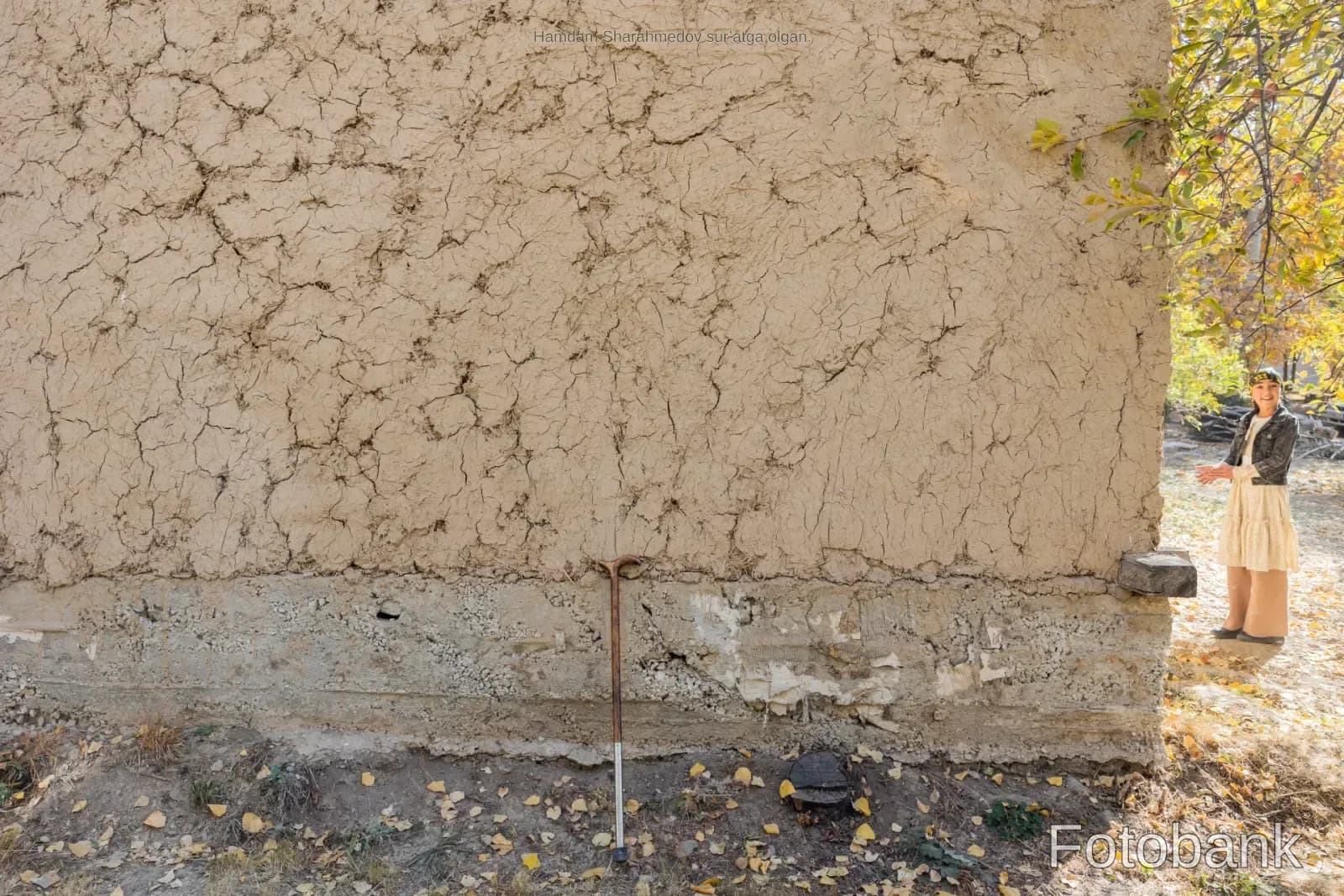 Rural life scene with a person near a mud wall