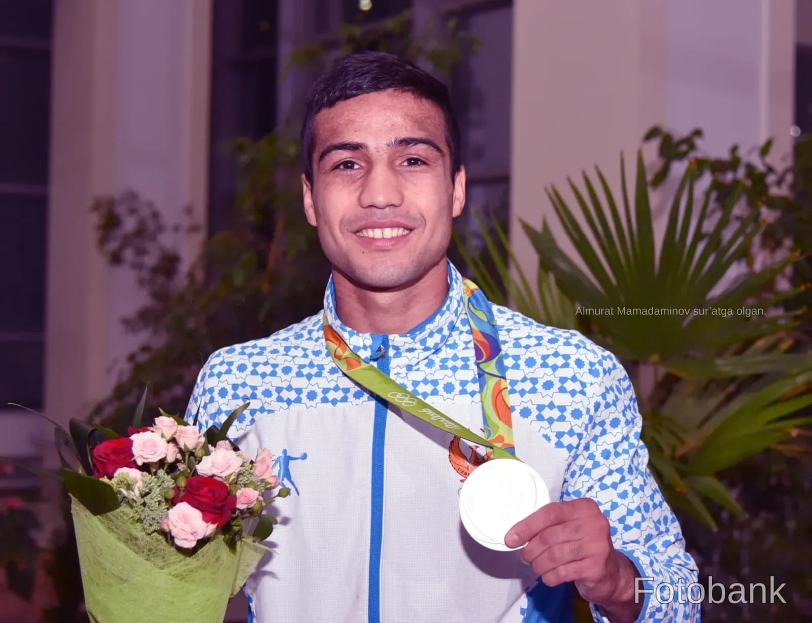 Portrait of an athlete holding a medal and a bouquet