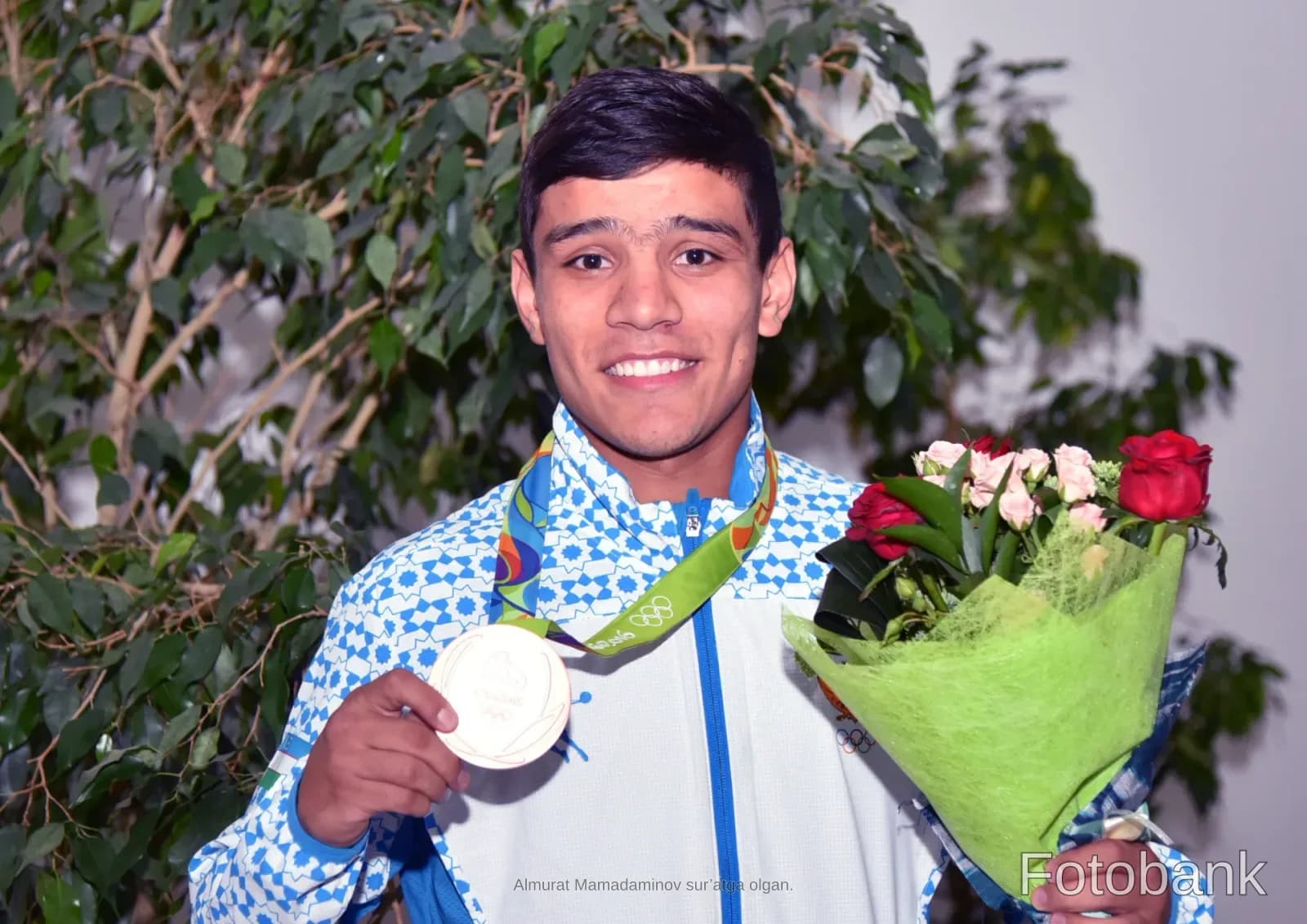 Athlete holding a medal and a bouquet of flowers