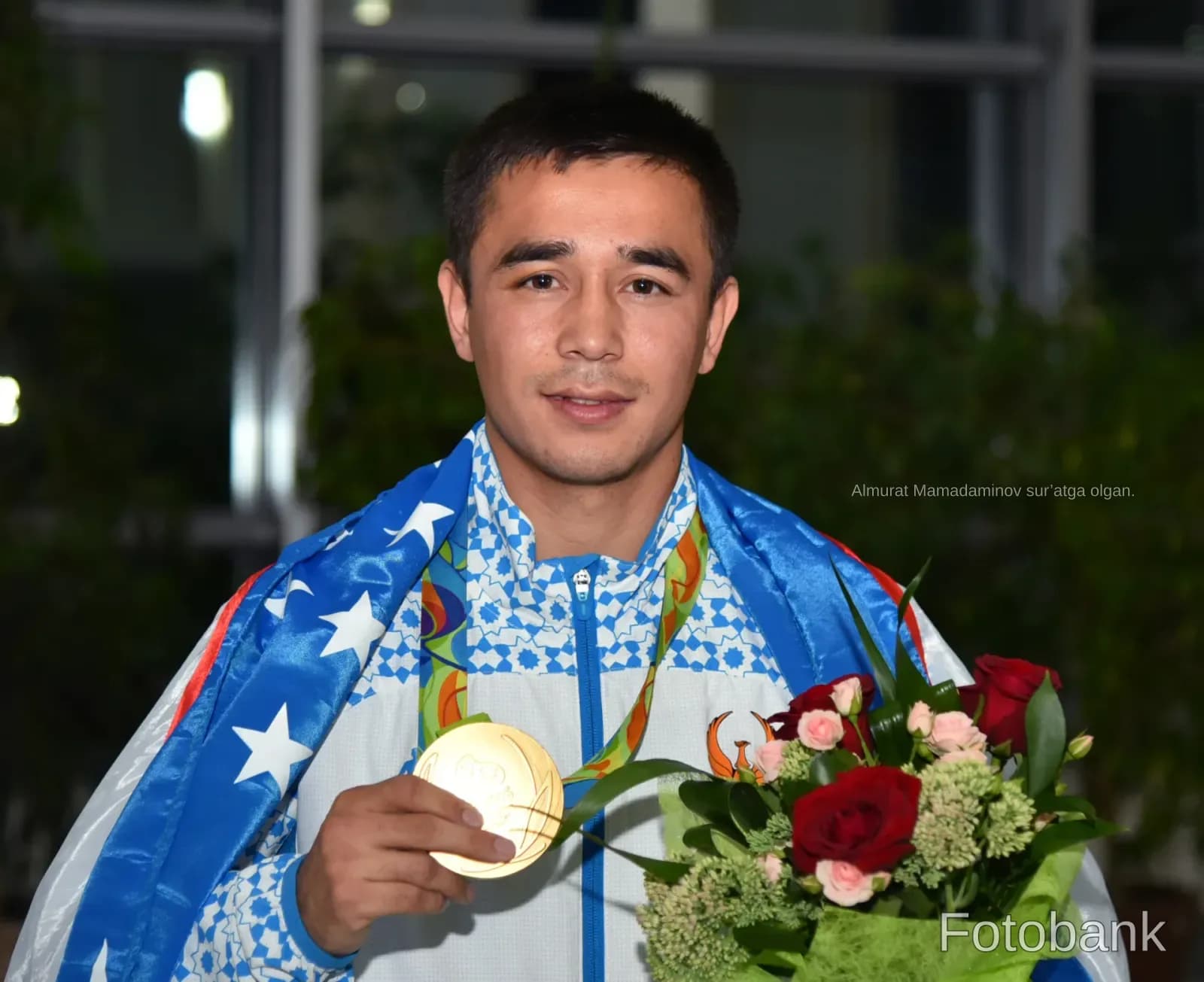 Athlete holding a medal and flowers