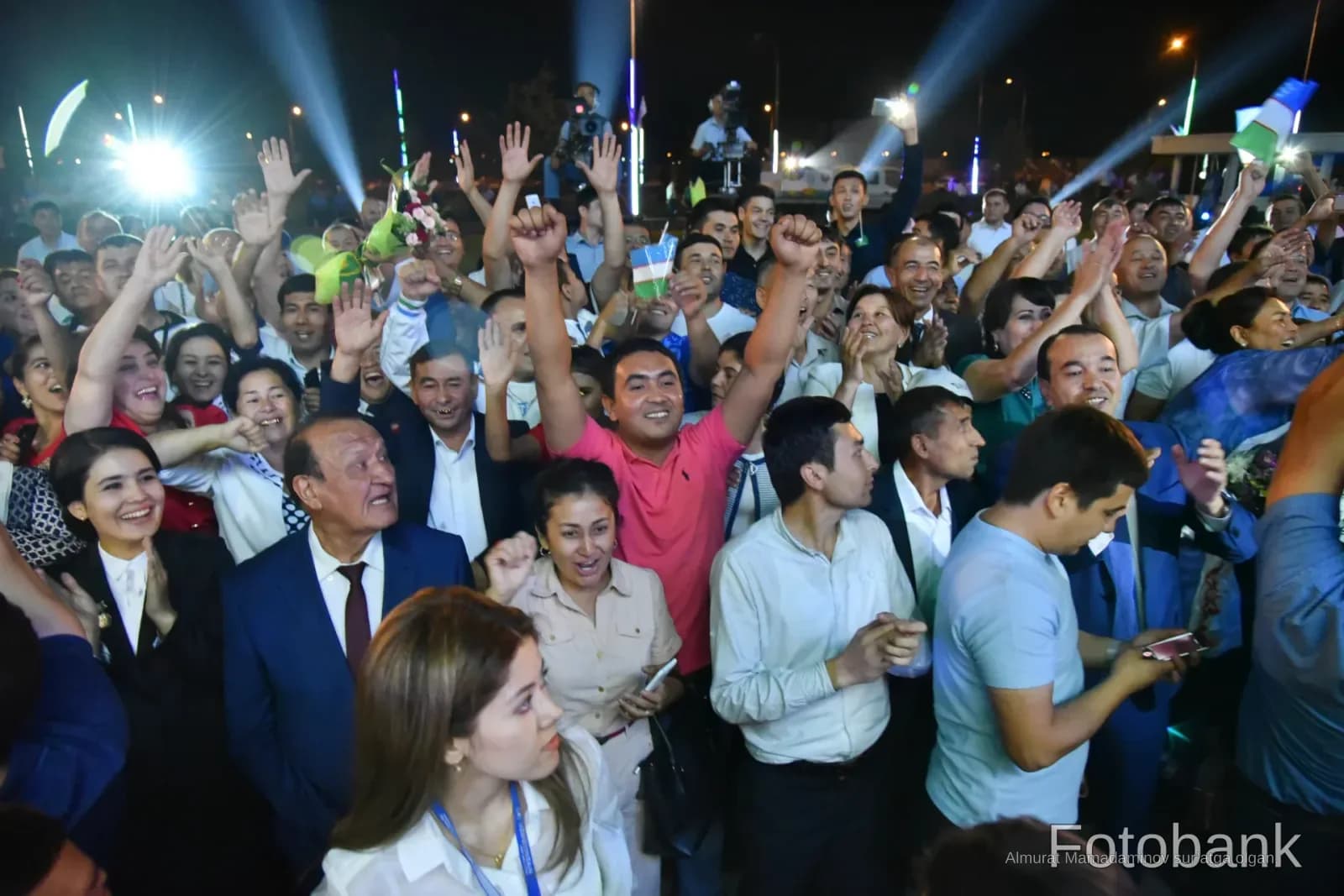 Crowd of people cheering with raised hands