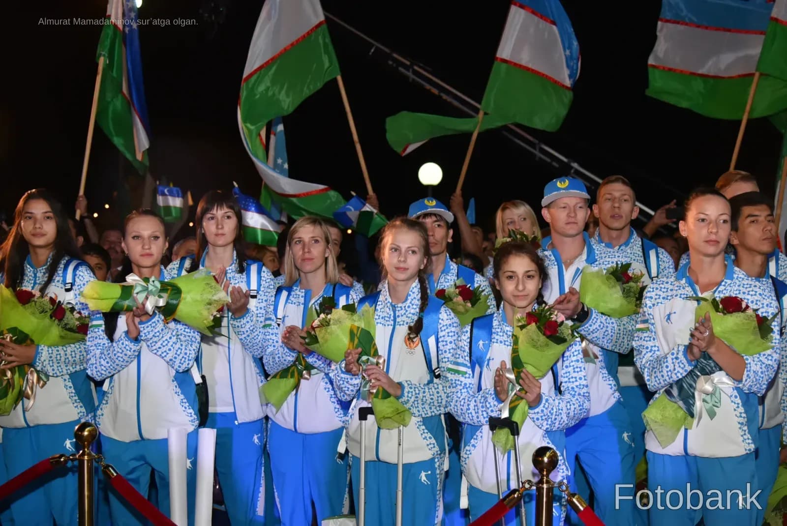 Athletes in matching sportswear holding bouquets