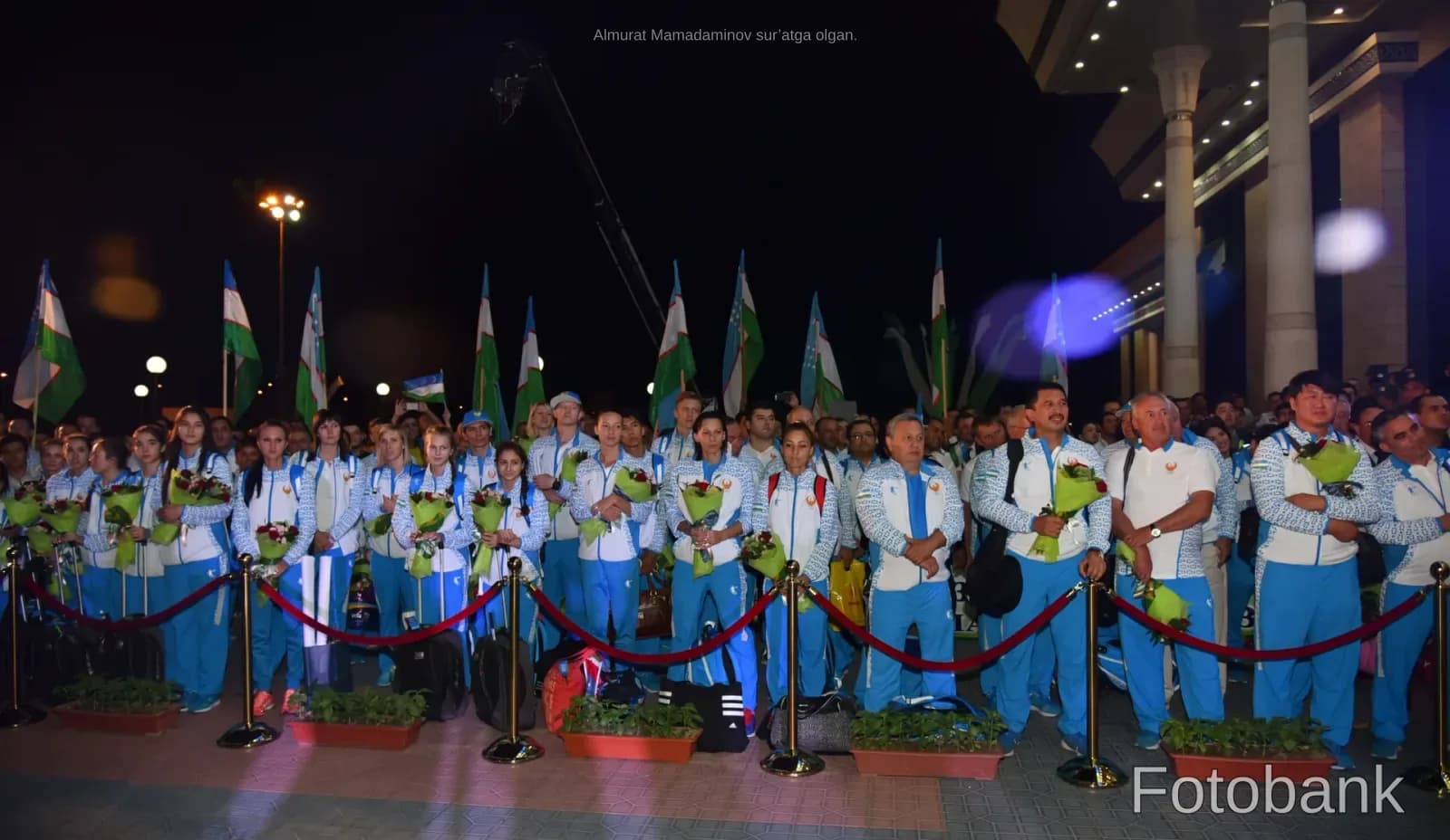 Athletes standing in formation with flowers