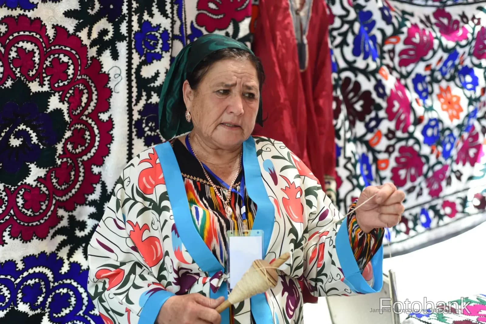 Naqshli matolardan oldin shpindel bilan ishlayotgan ayol