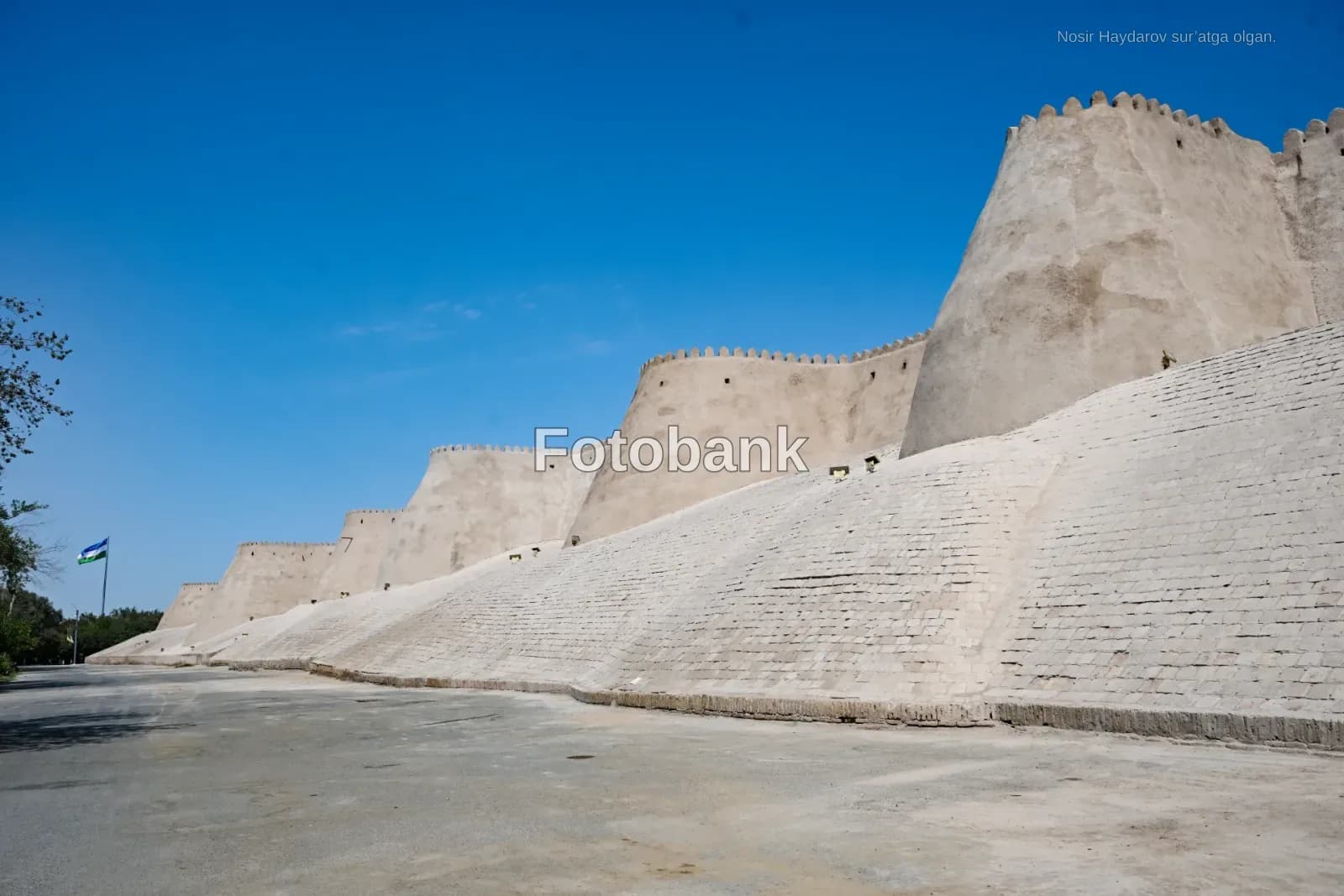 Ancient defensive mud-brick fortress wall against clear blue sky