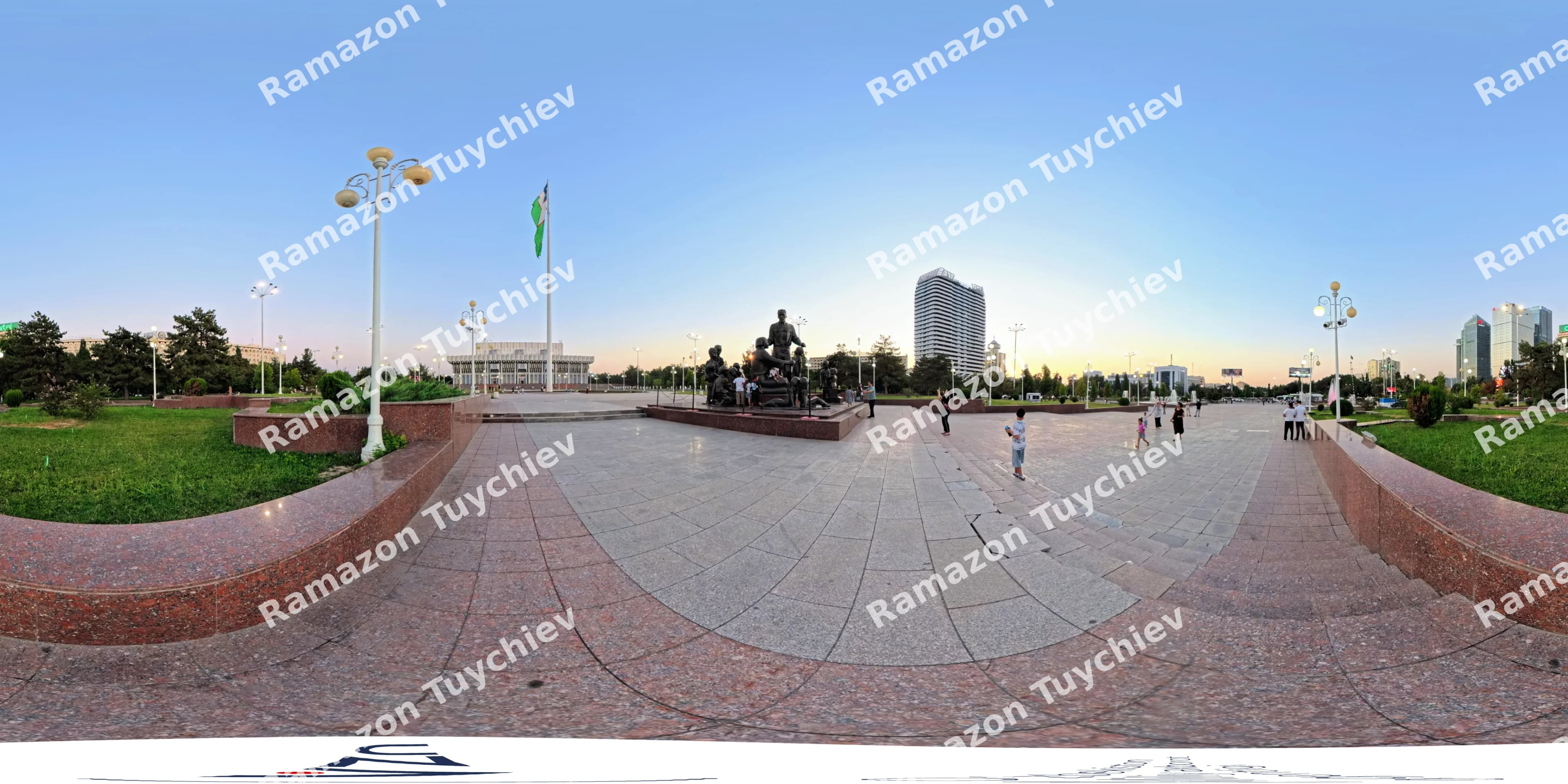 Люди идут по общественной площади с памятником и флагом