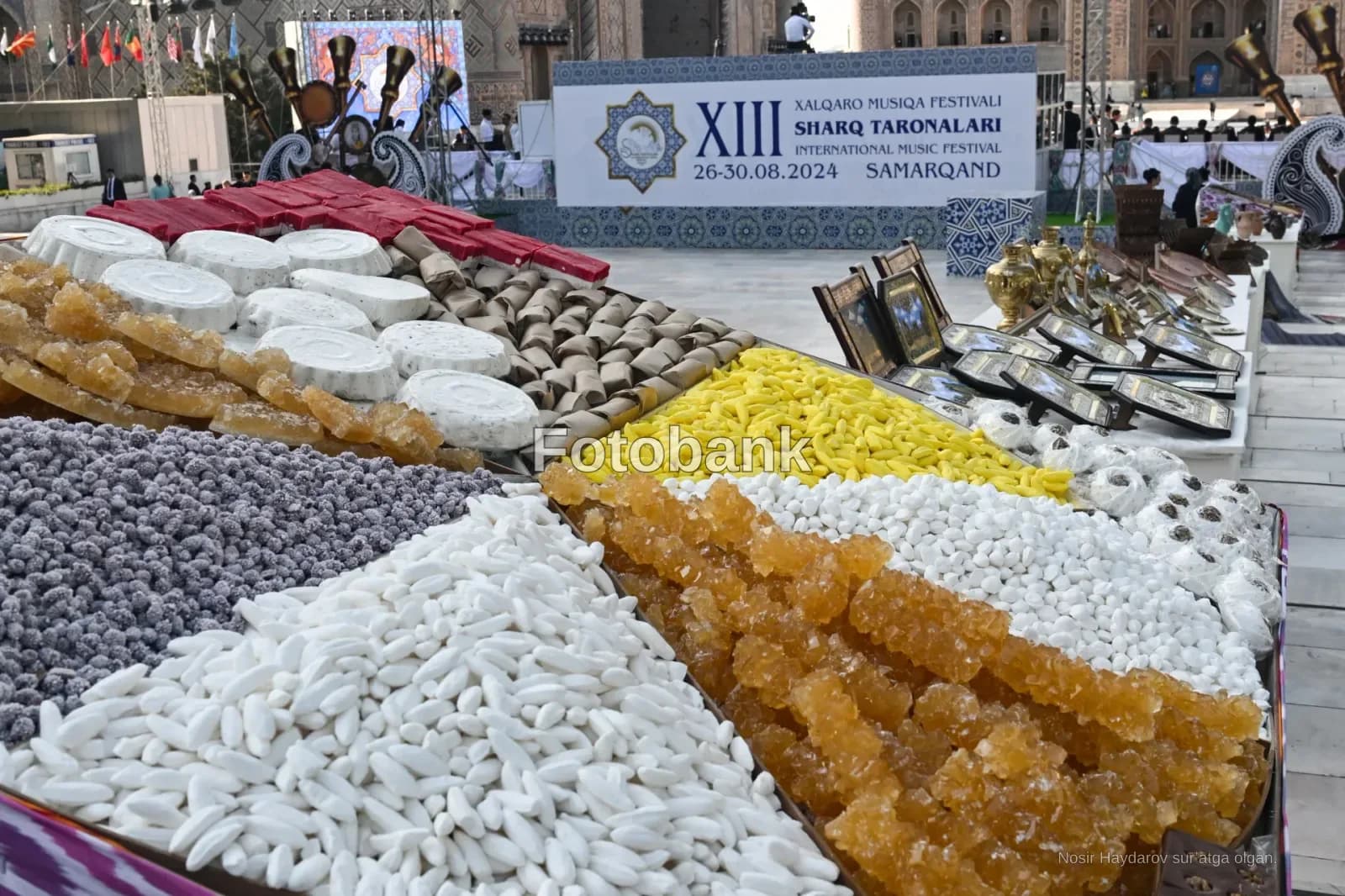 Ассортимент традиционных сладостей и кондитерских изделий, выставленный на столах на открытом воздухе