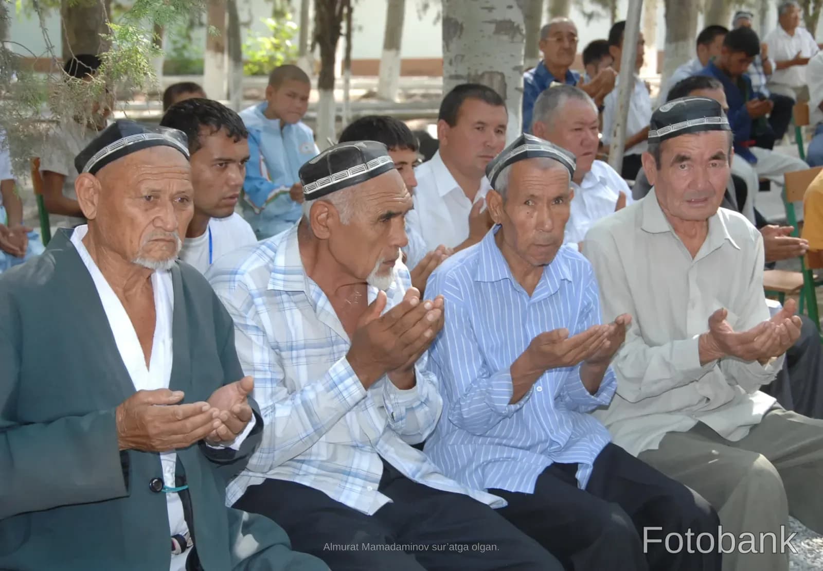 Group of men holding hands up in outdoor gathering