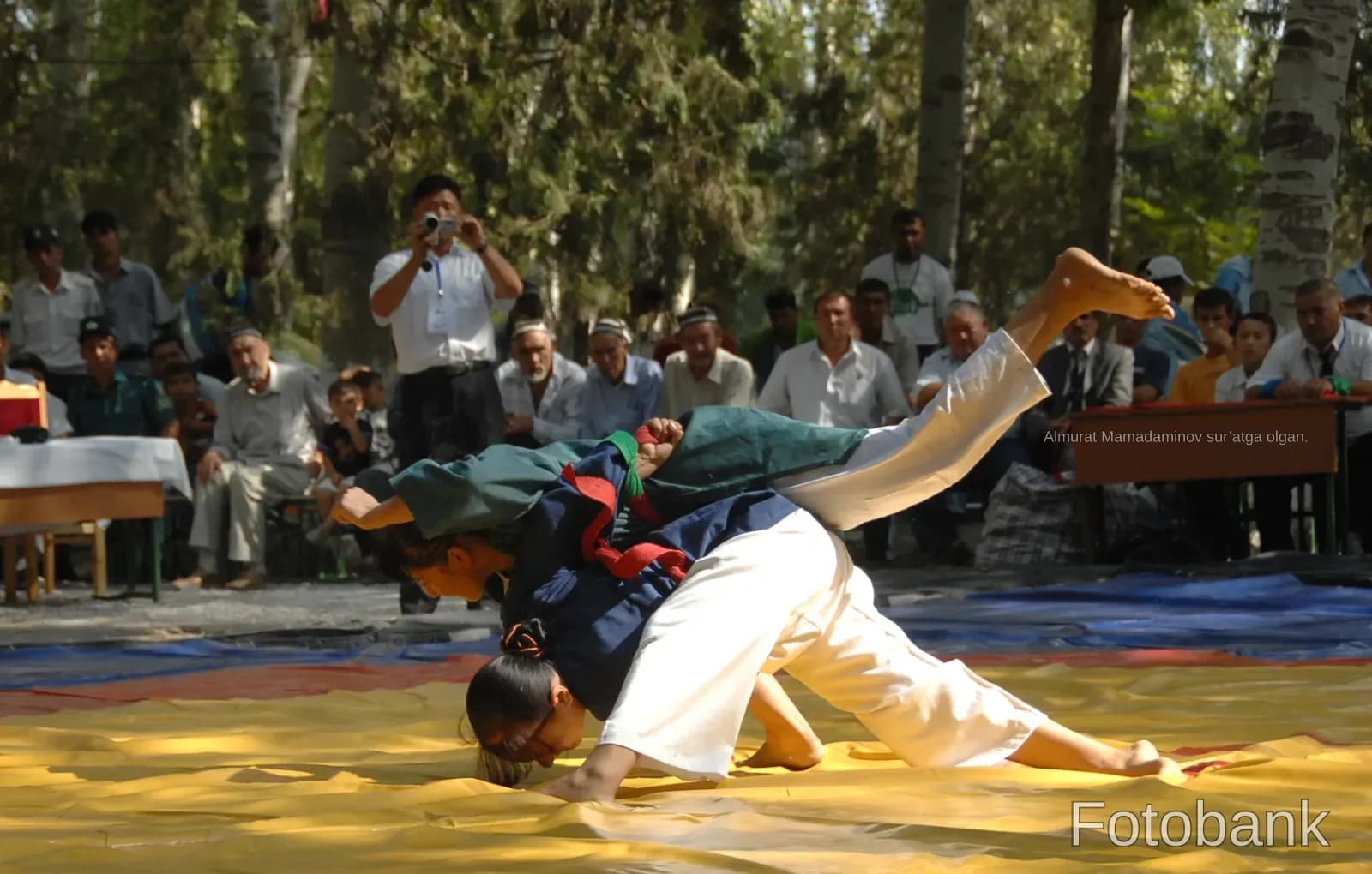 Athletes competing in a wrestling match outdoors