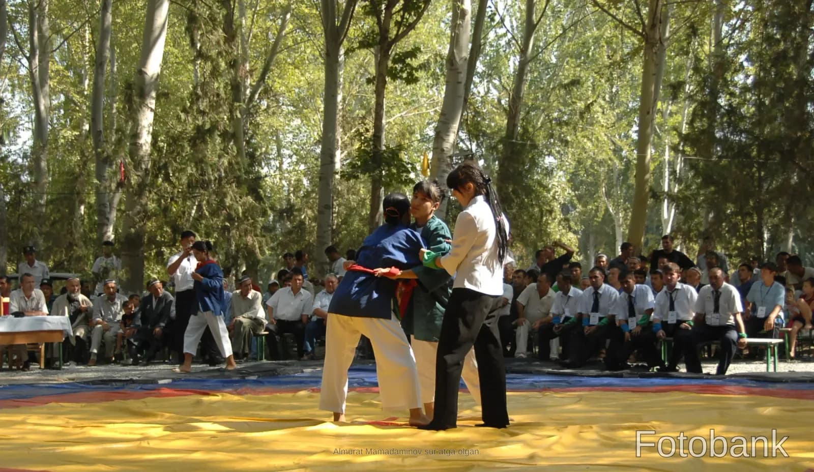 Athletes competing on a mat outdoors