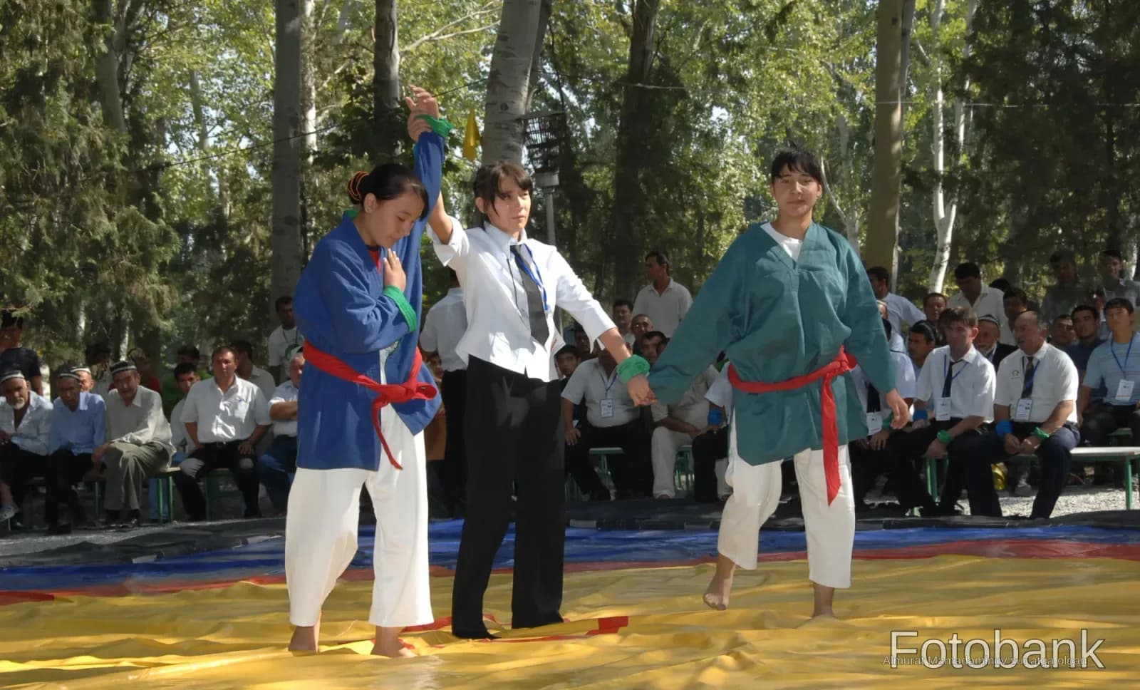 Athletes and referee on wrestling mat