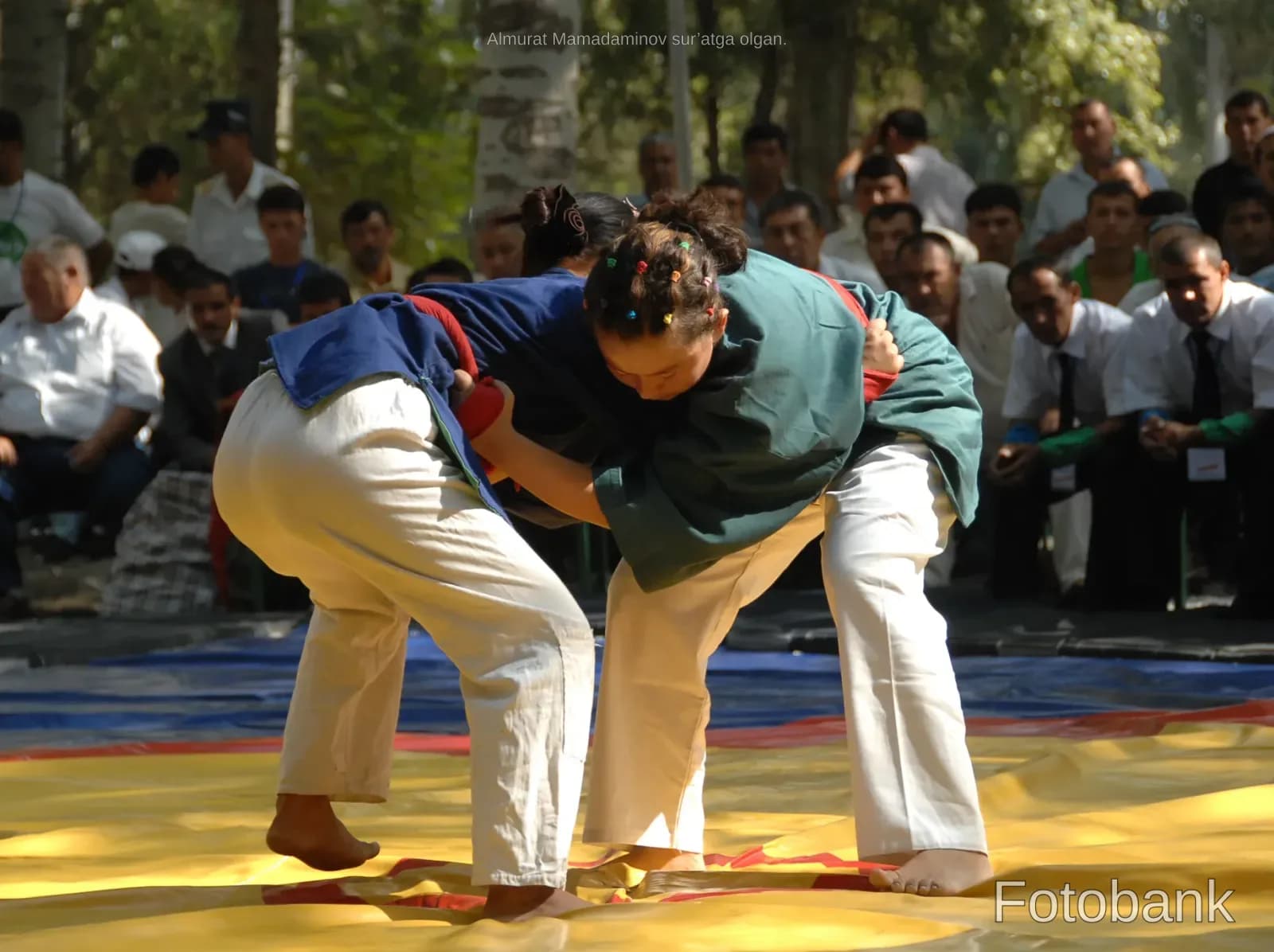 People competing in a wrestling match outdoors