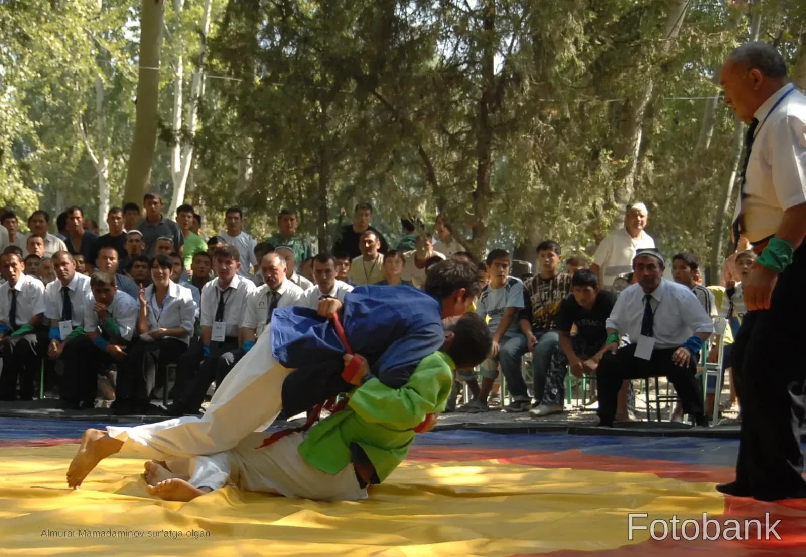 Wrestlers competing on a mat outdoors