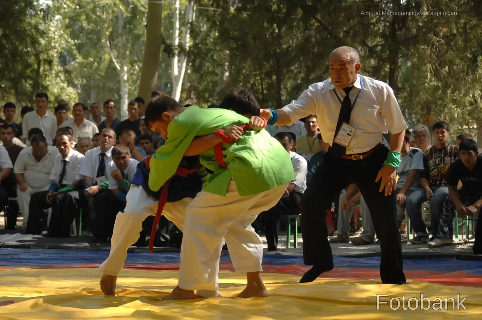 Athletes competing in a match outdoors watched by spectators