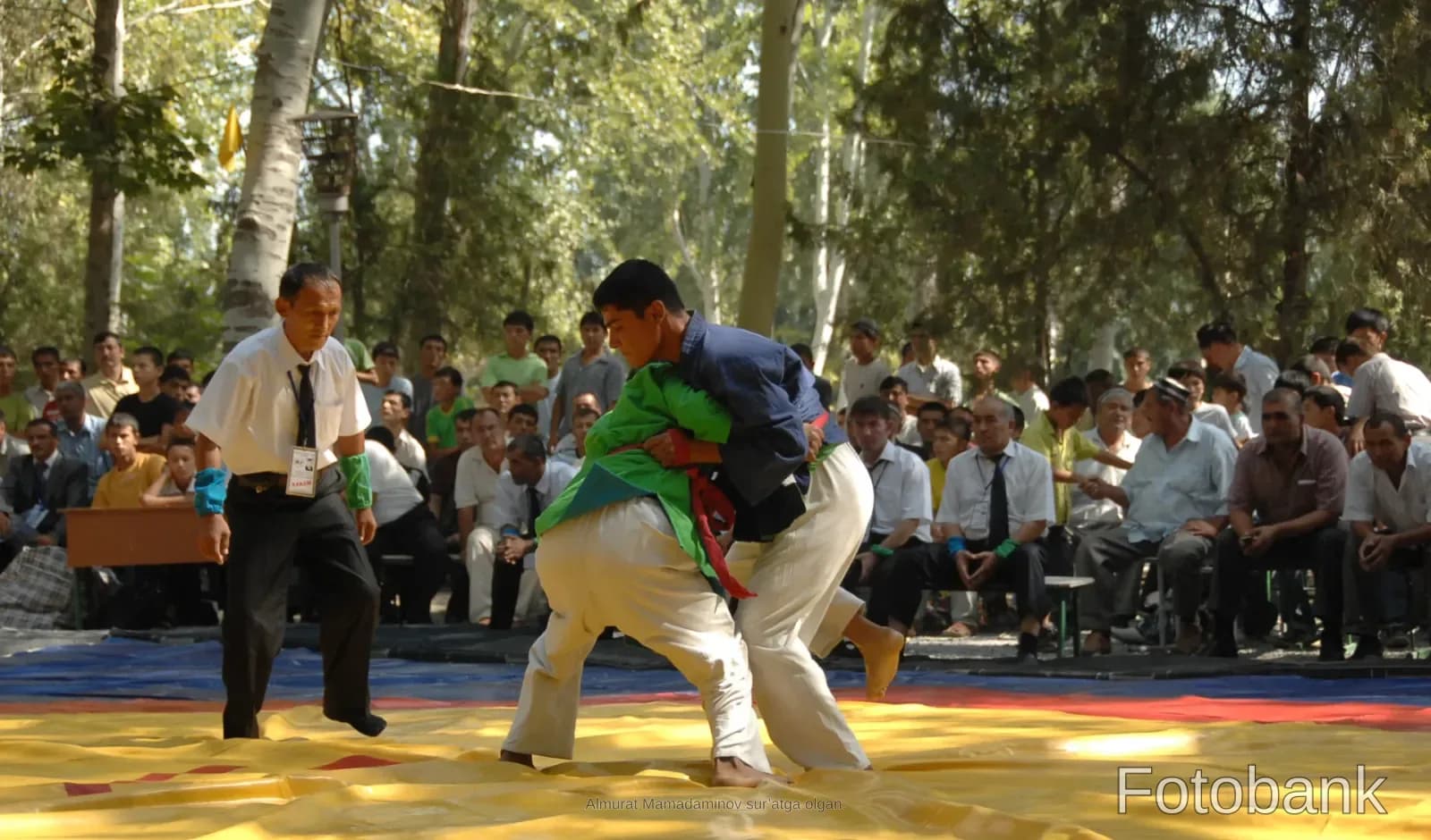 Competitors wrestling outdoors in an athletic match