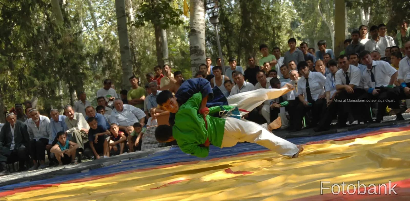 Wrestlers competing on mat outdoors