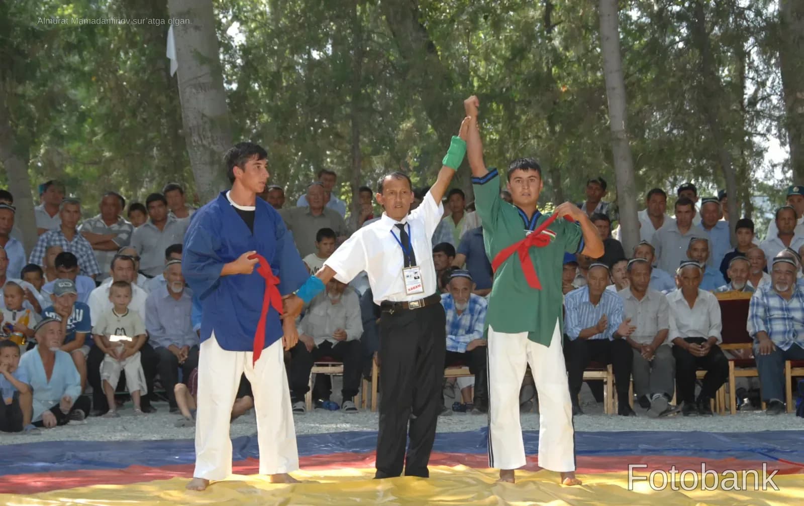 Referee holding up a wrestler's hand in victory