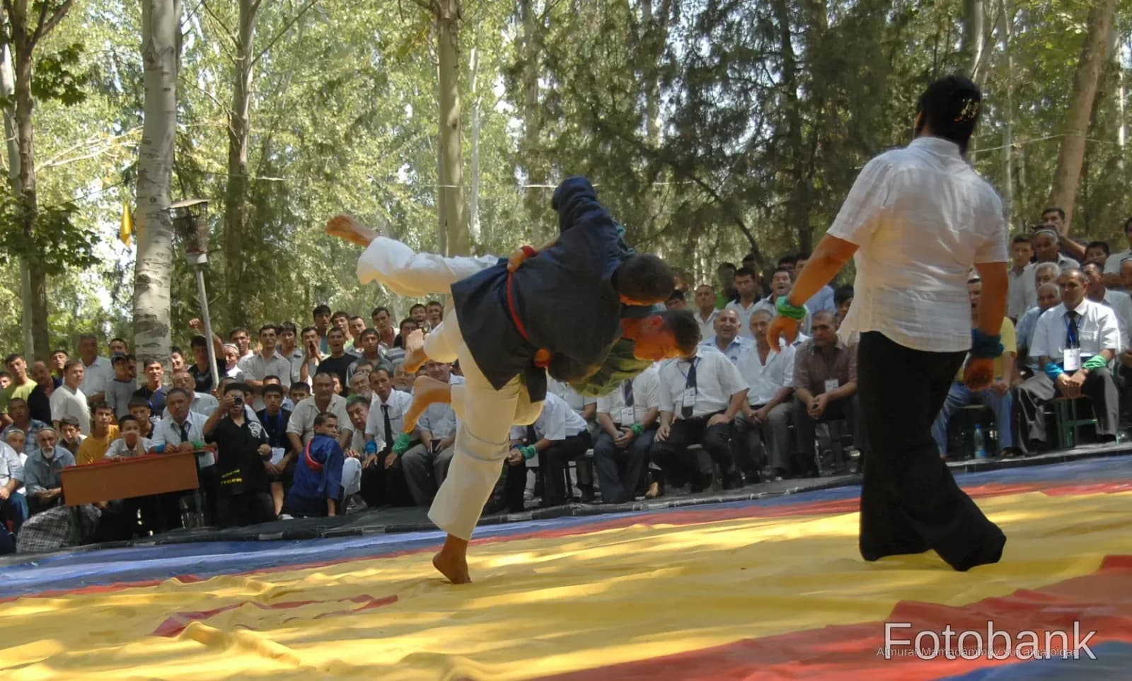 Competitors grapple during an outdoor wrestling match
