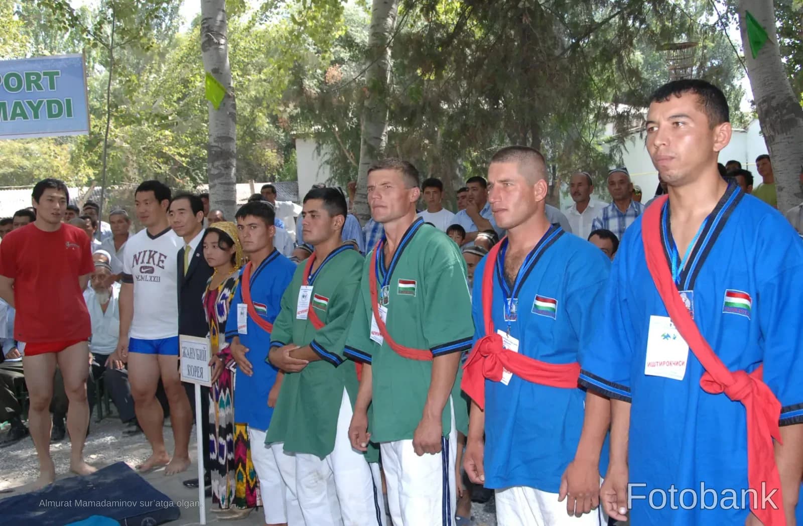 Athletes in traditional sporting attire stand outdoors during a competition