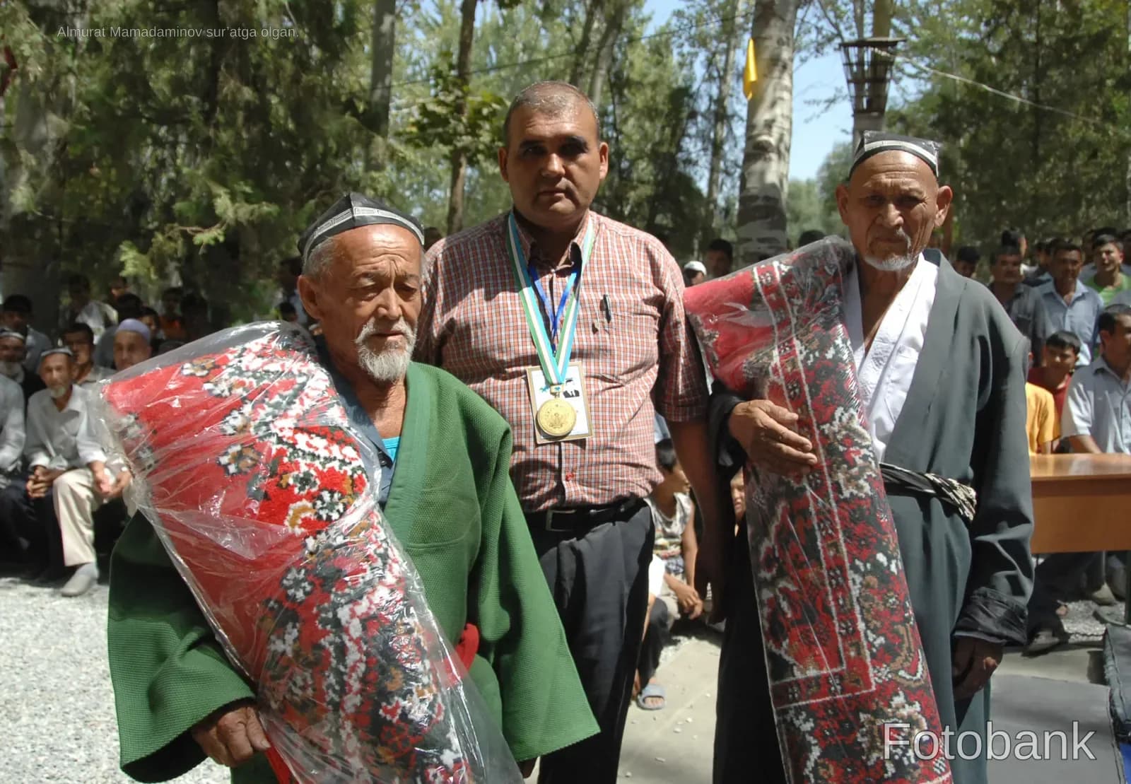 Men holding rolled carpets outdoors