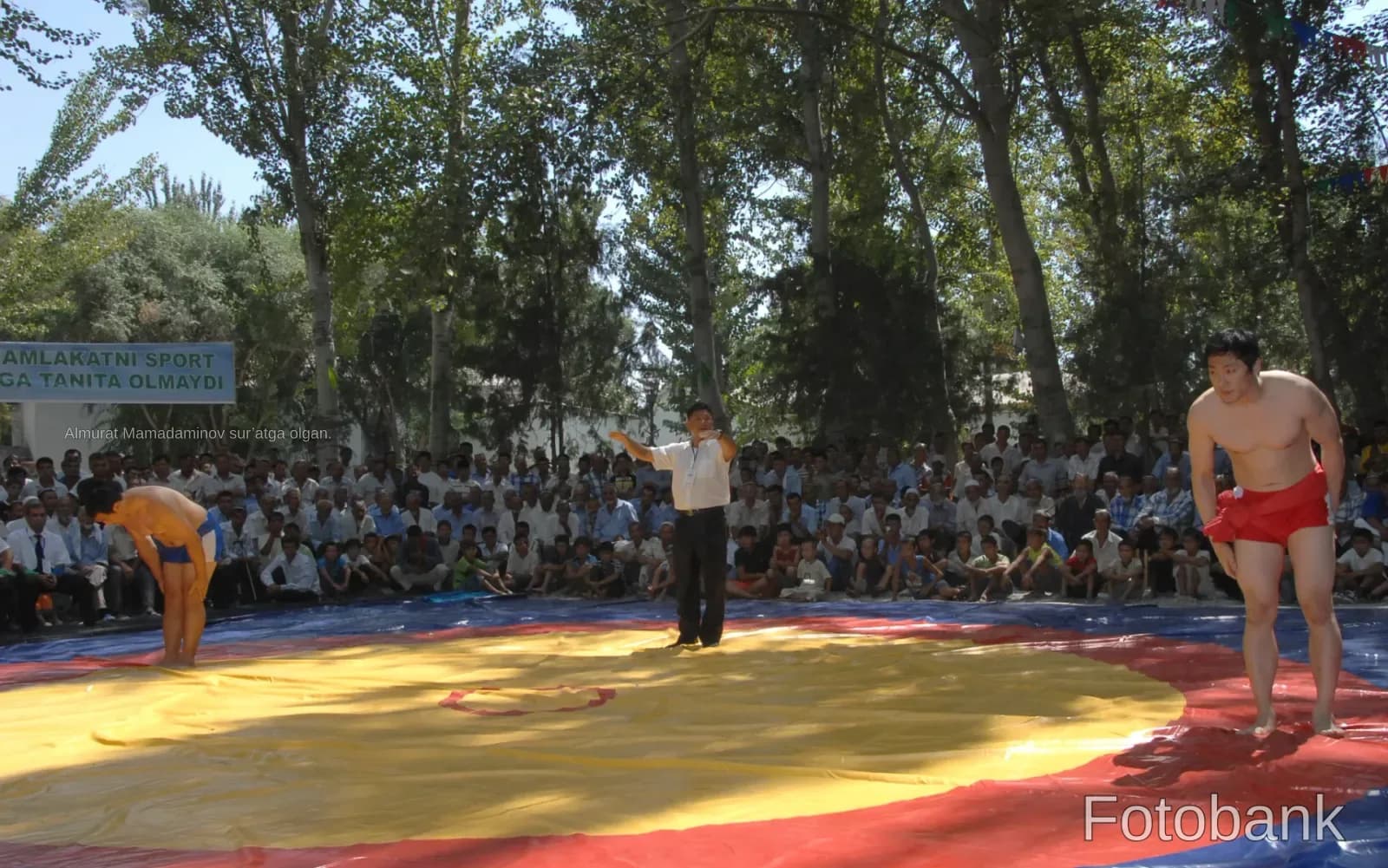 Wrestlers competing on an outdoor mat