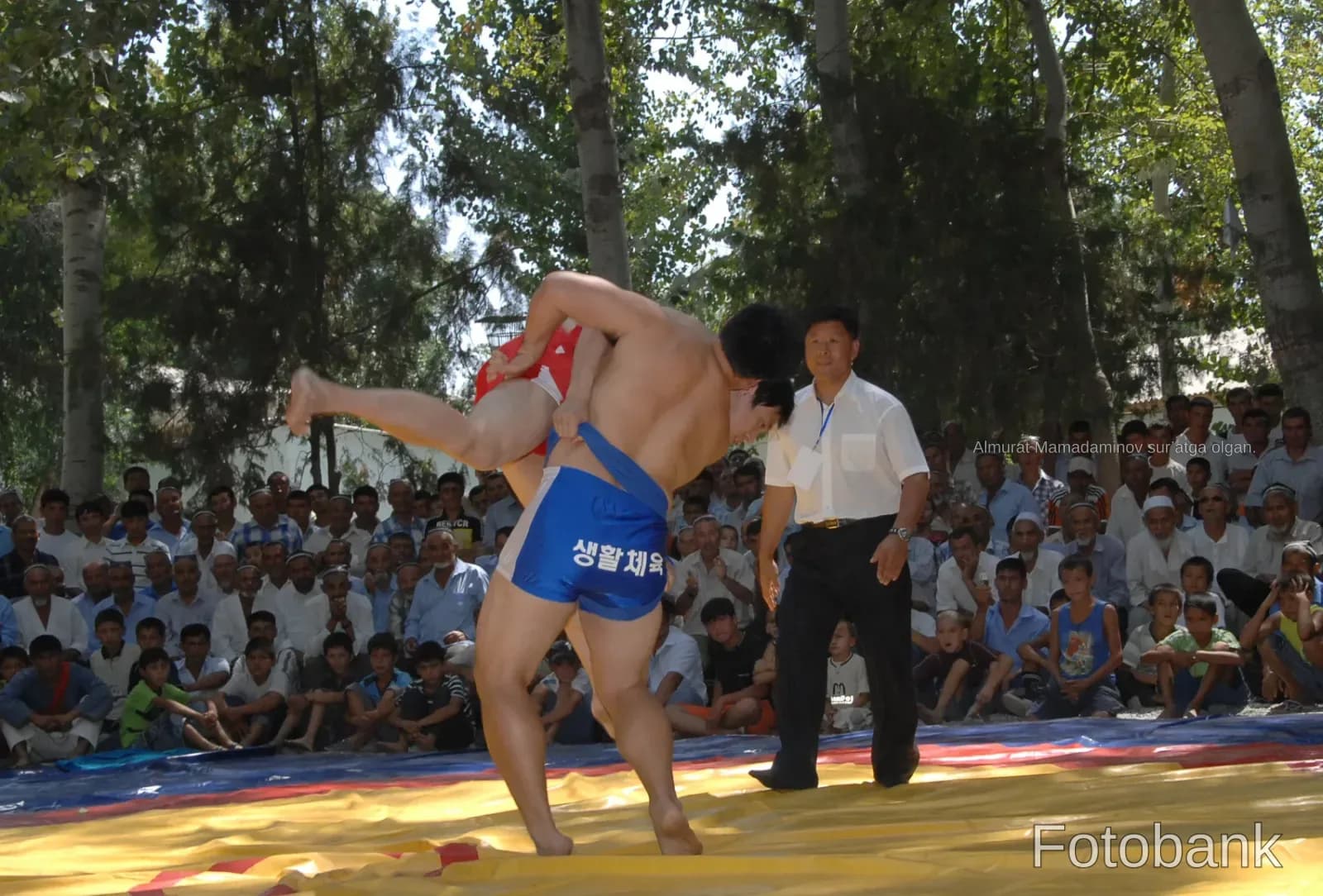 Athletes competing in a wrestling match outdoors