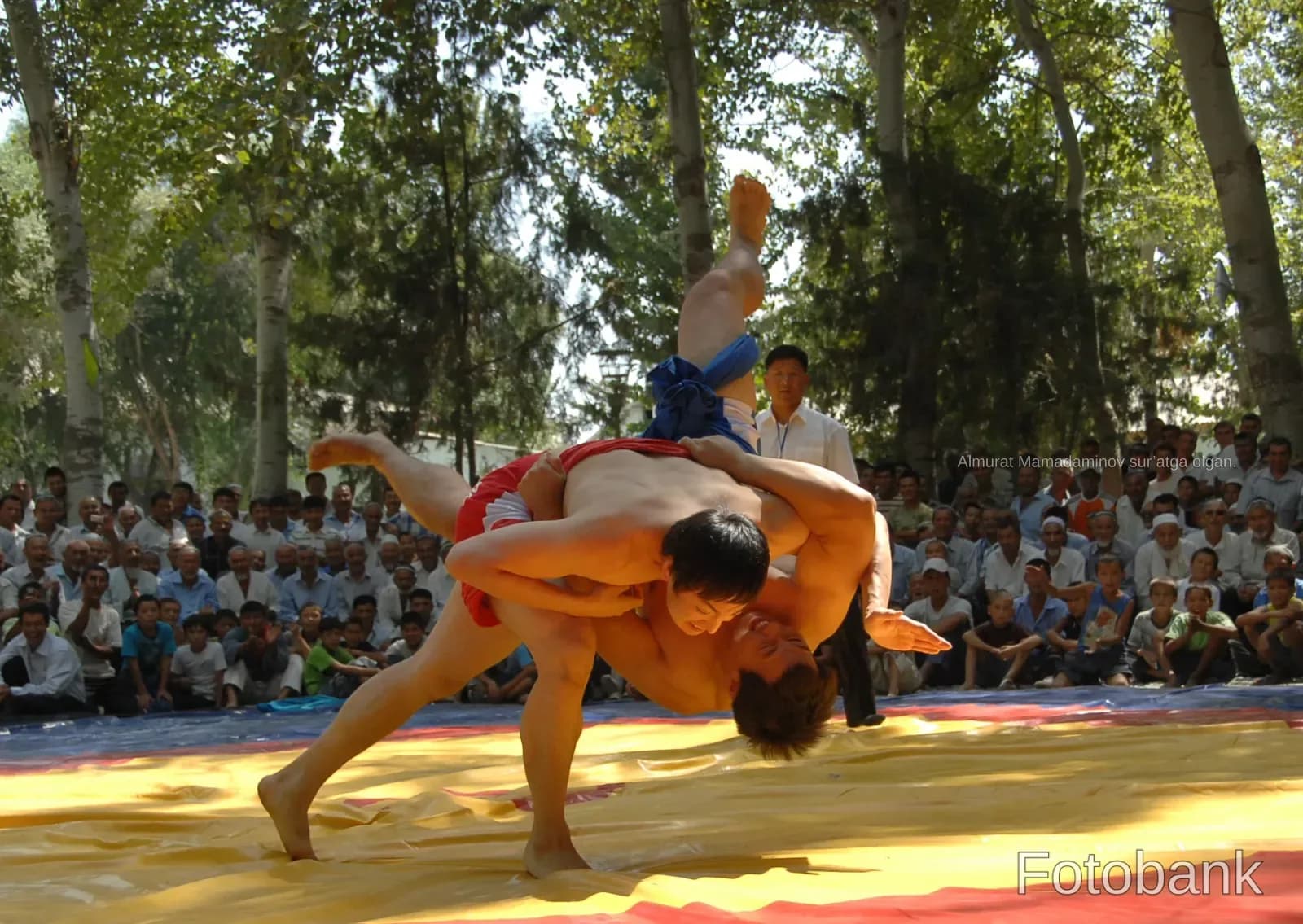 Athletes competing in a wrestling match outdoors