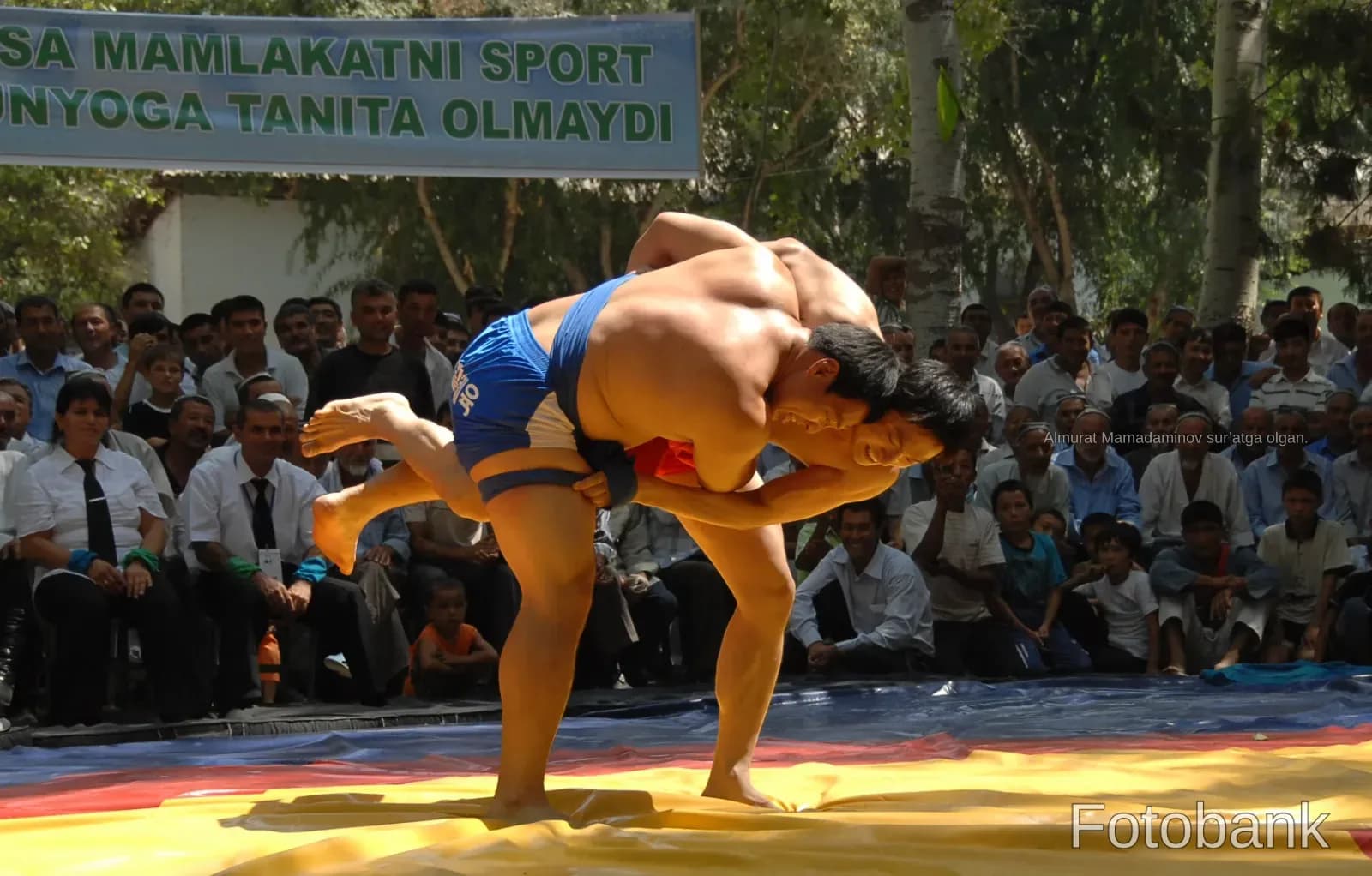 Athletes competing in a wrestling match outdoors