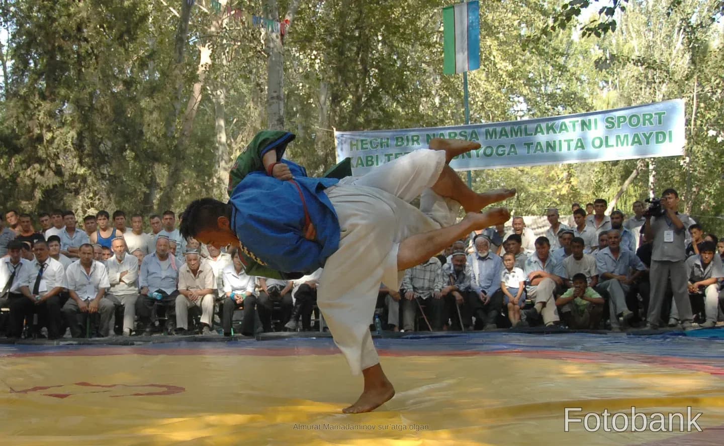 Wrestlers competing on an outdoor mat