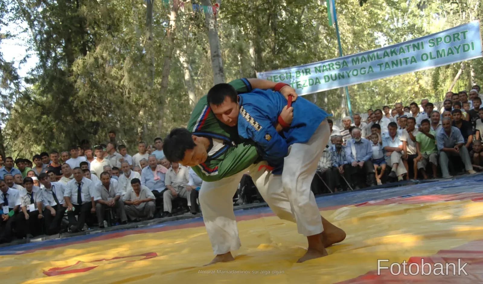 Athletes competing in a wrestling match on a mat