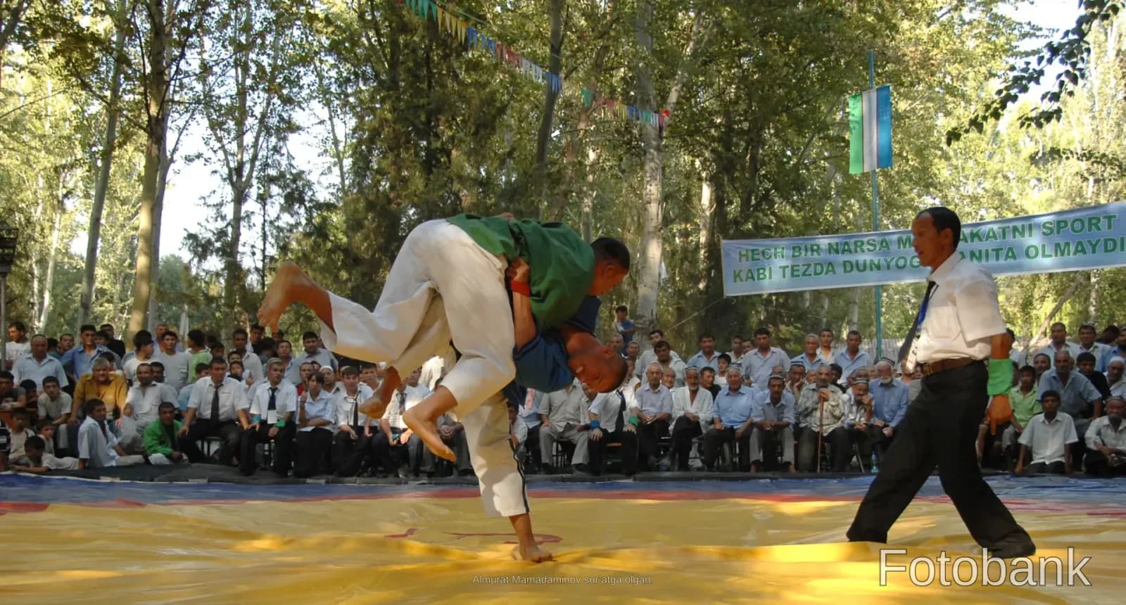 Athletes competing in a wrestling match outdoors