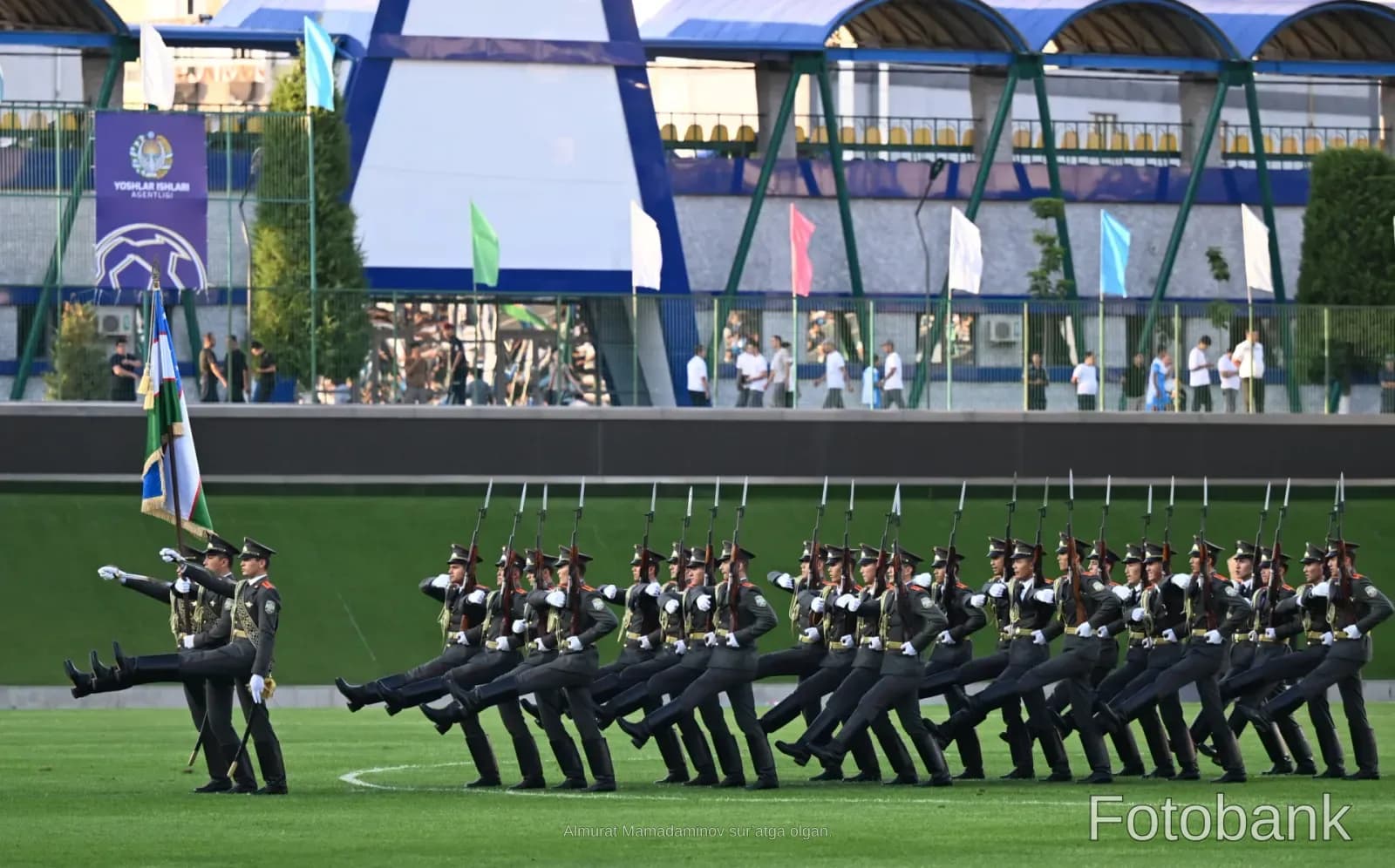 Military personnel marching in a stadium