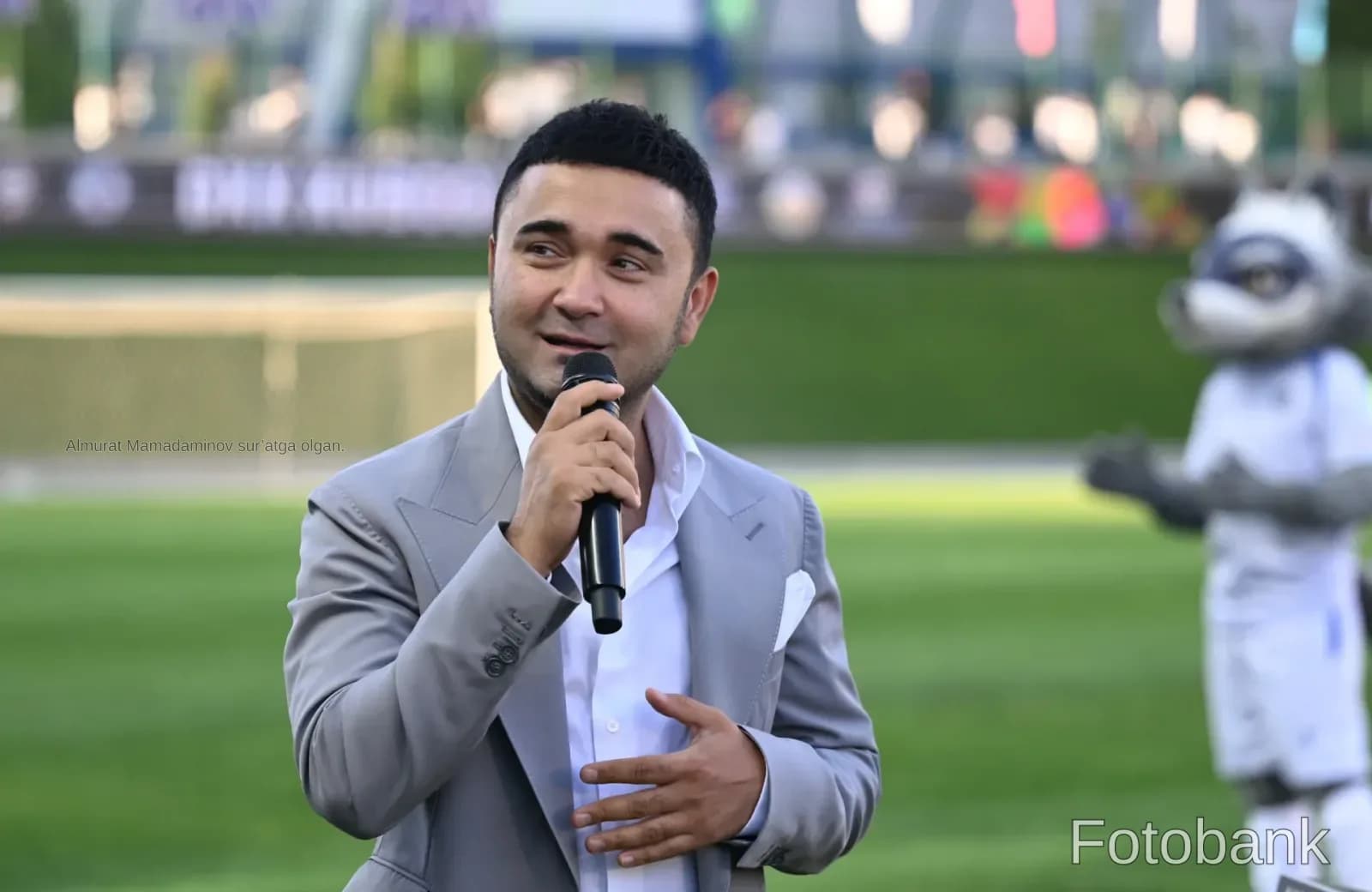 Man speaking into a microphone outdoors