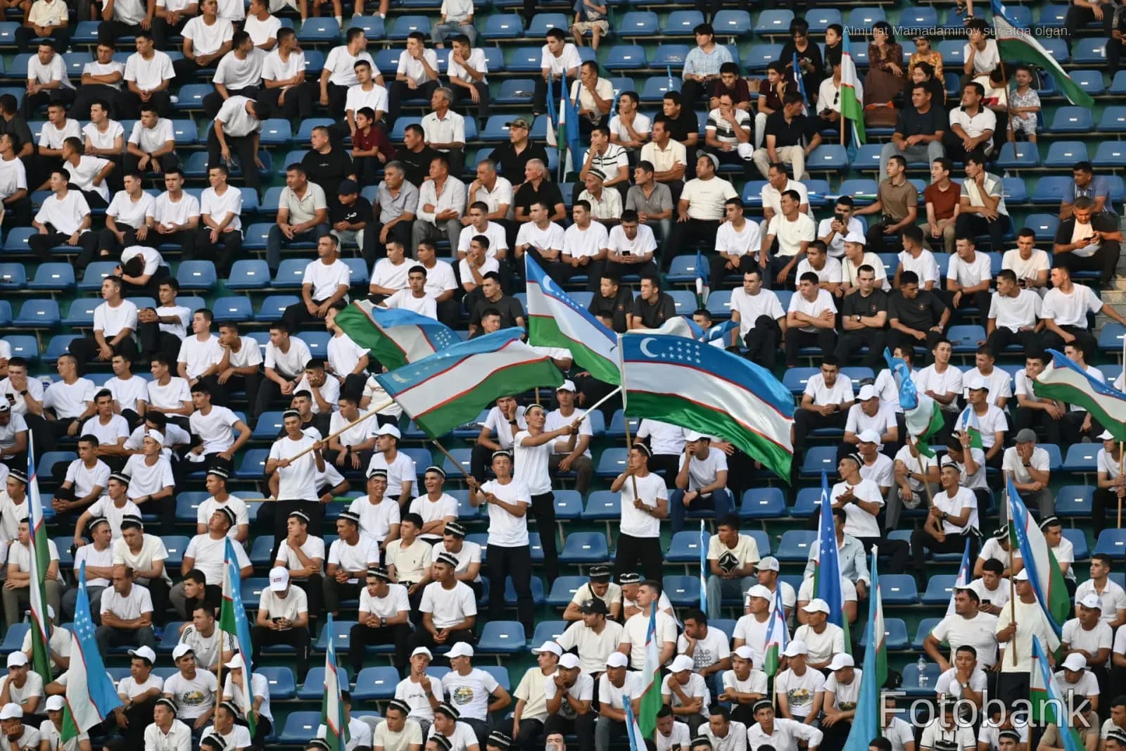 Spectators seated in stadium stands holding flags