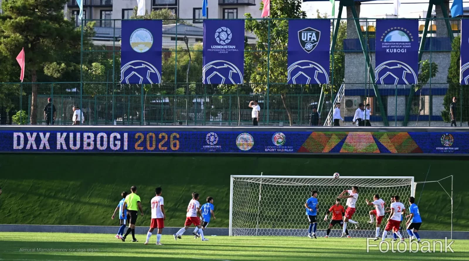 Football match in progress on a green stadium pitch