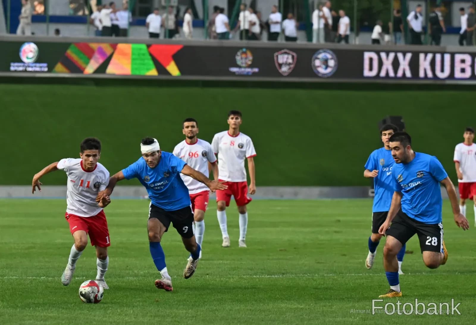 Athletes competing in a football match on a stadium pitch