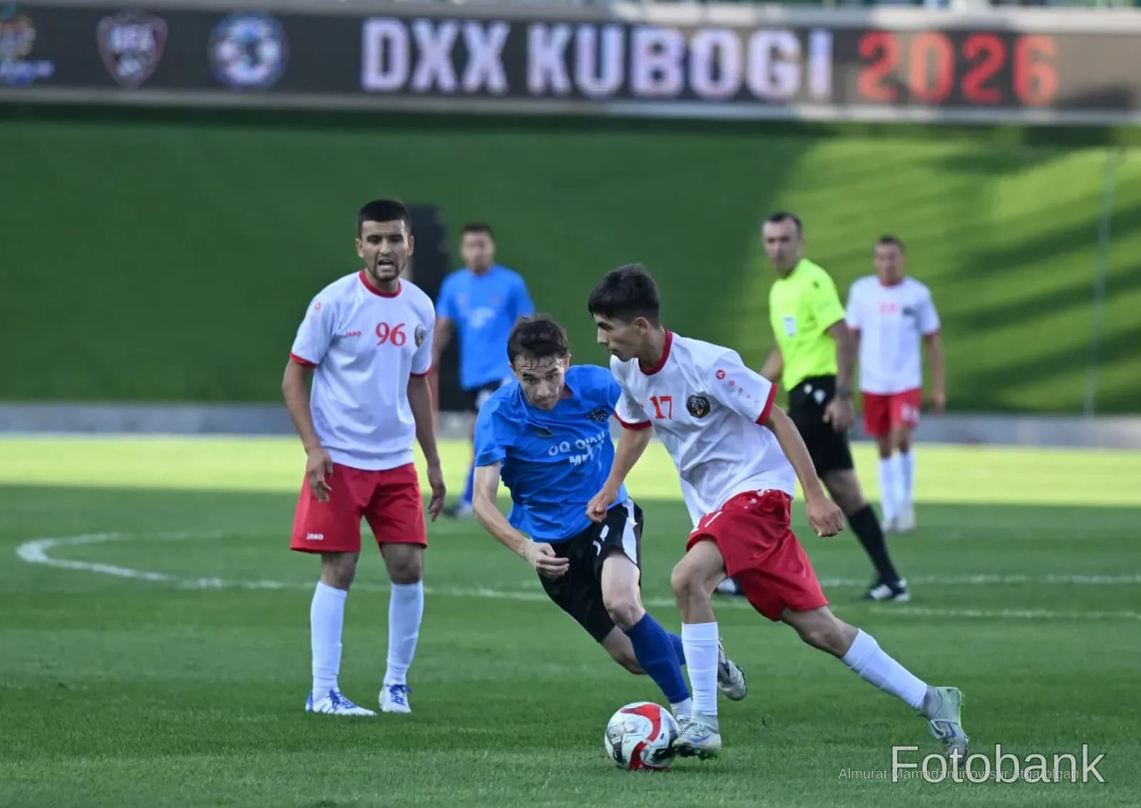 Players competing in a football match on a grass field