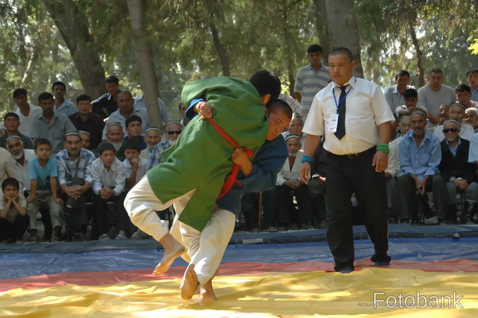 Wrestlers competing on mat outdoors